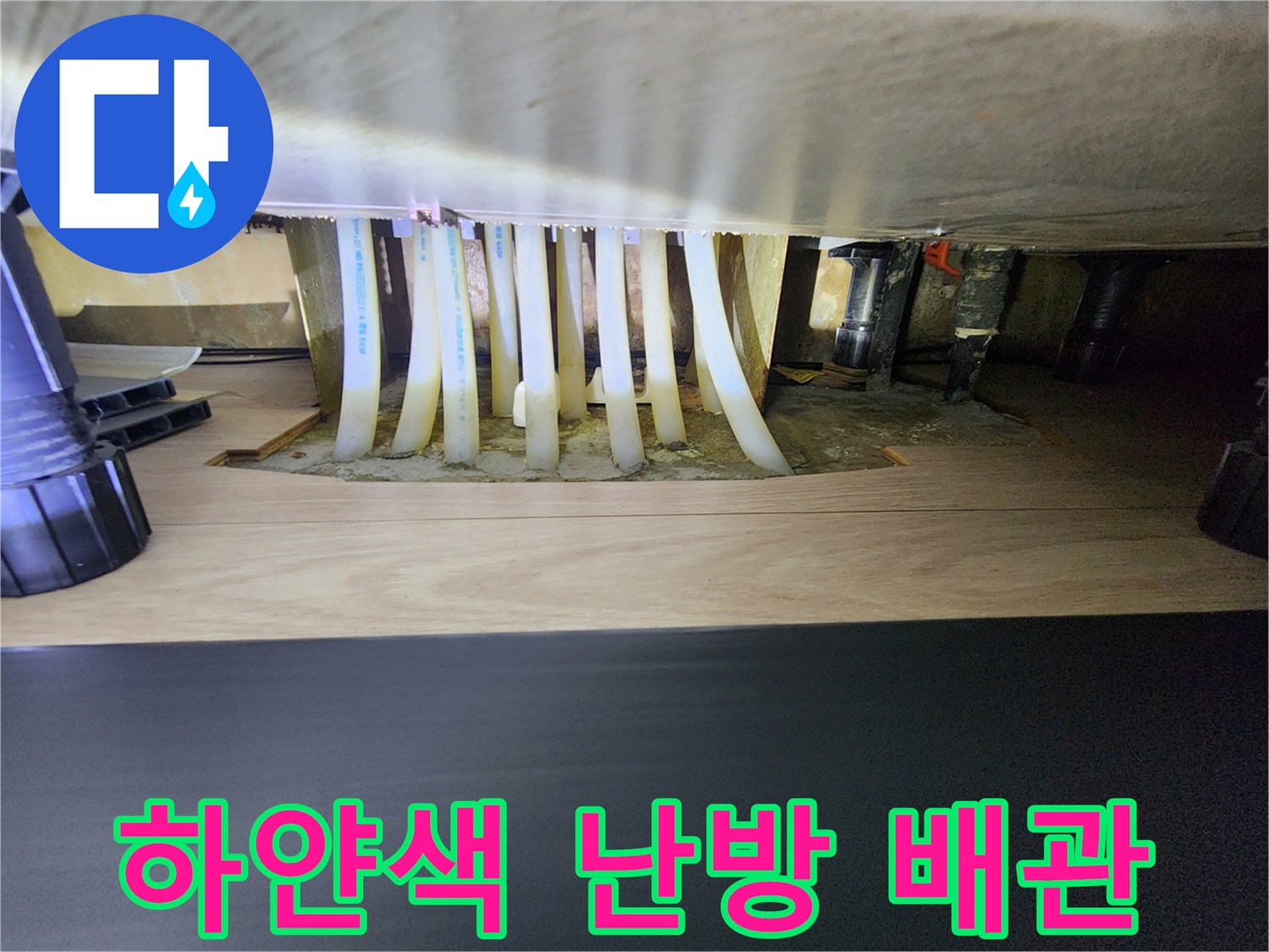 싱크대 하부장 내부의 흰색 분배기 배관 및 연결 부속
