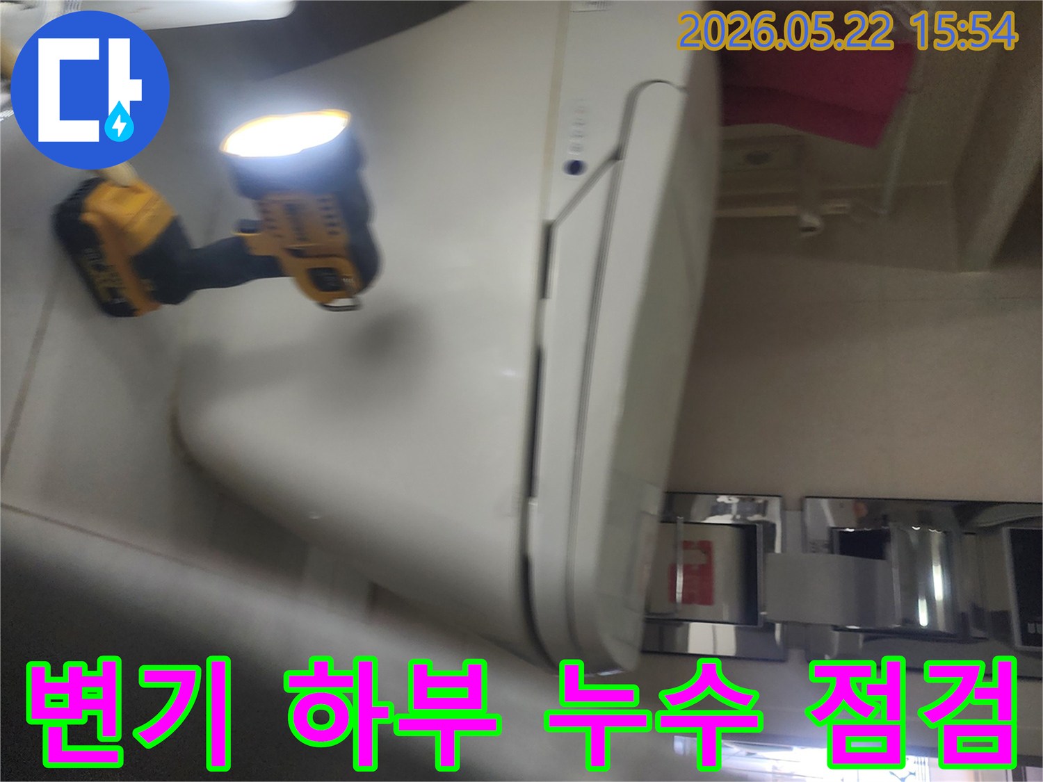 용인 보정동 아파트 욕실에서-변기 하부의 누수 여부를-확인하기 위해-작업등을 비추며-정밀하게 점검하는-누수 전문가의 현장 작업