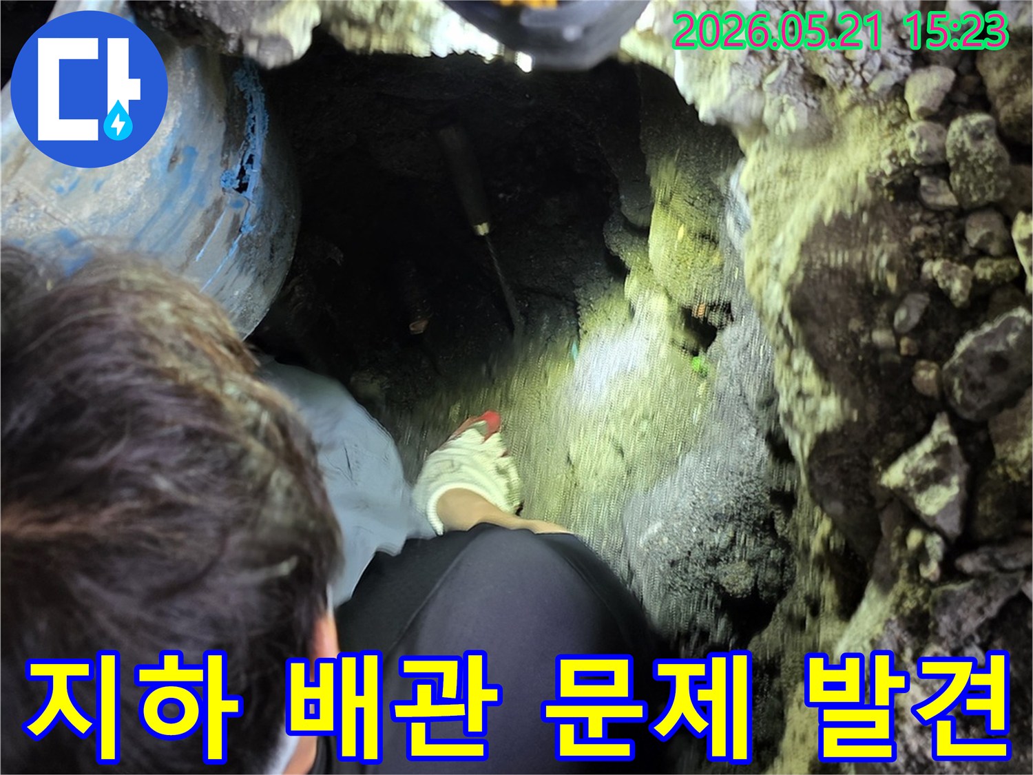 전문 엔지니어가-어두운 굴착 현장에서-손전등을 비추며-지하 매설 배관의-숨겨진 누수 문제점을-정확히 발견하는 모습입니다.