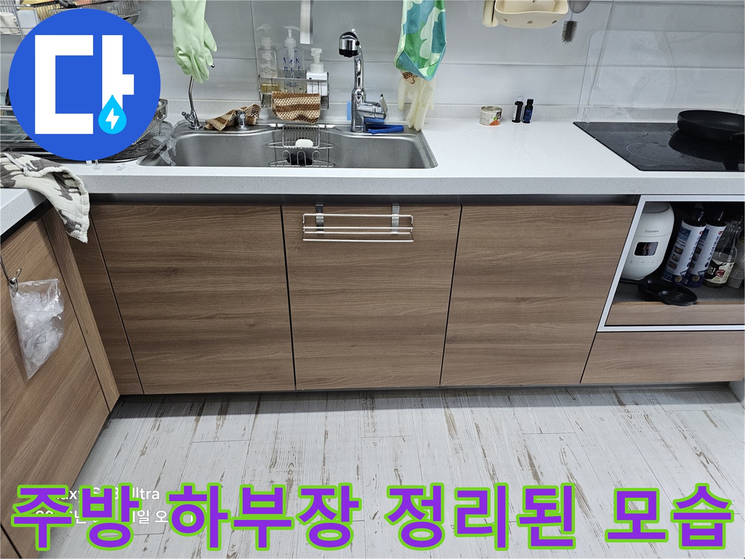 누수 지점을 찾기 위해 싱크대 밑 수납장을 비워둔 현장 사진입니다.