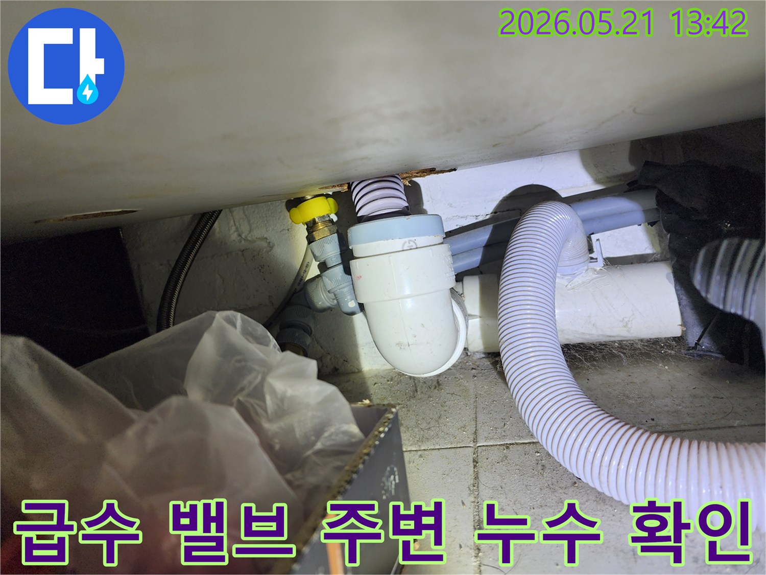 세탁실 급수 밸브와 연결된 호스 주변에서 발생하는-미세한 물샘 현상을 찾아내기 위해 점검하는 모습입니다.