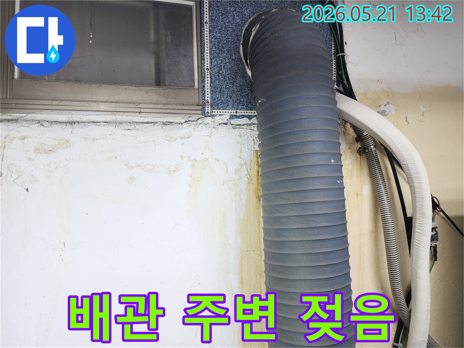 아파트-벽면의-배관-주변에서-누수가-발생하여-벽지가-손상되고-물자국이-선명하게-보이는-사진