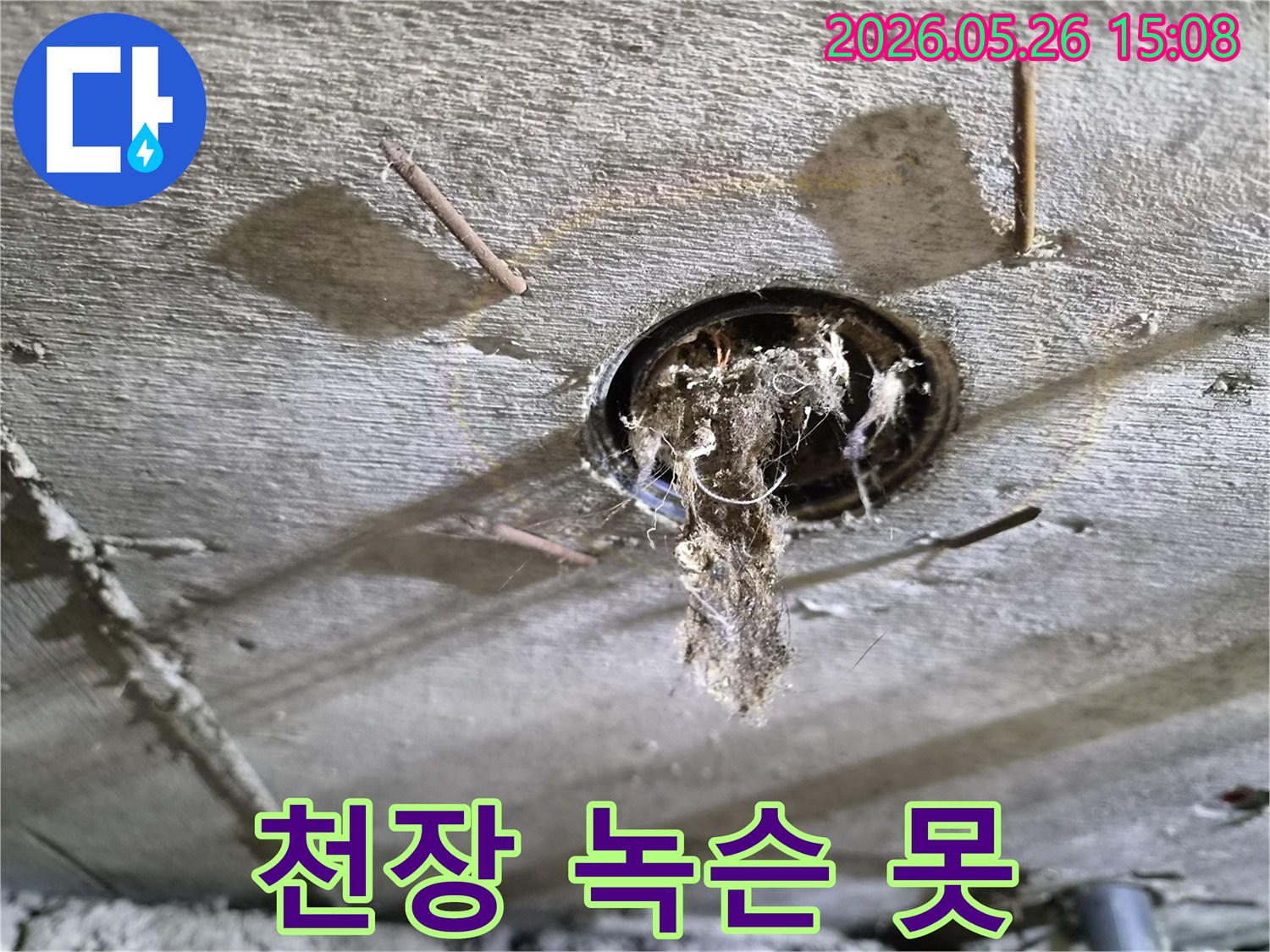 콘크리트 천장 구멍에서-녹슨 못과-오염된 이물질이-떨어지는-누수-현장의-상황을-보여주는-사진