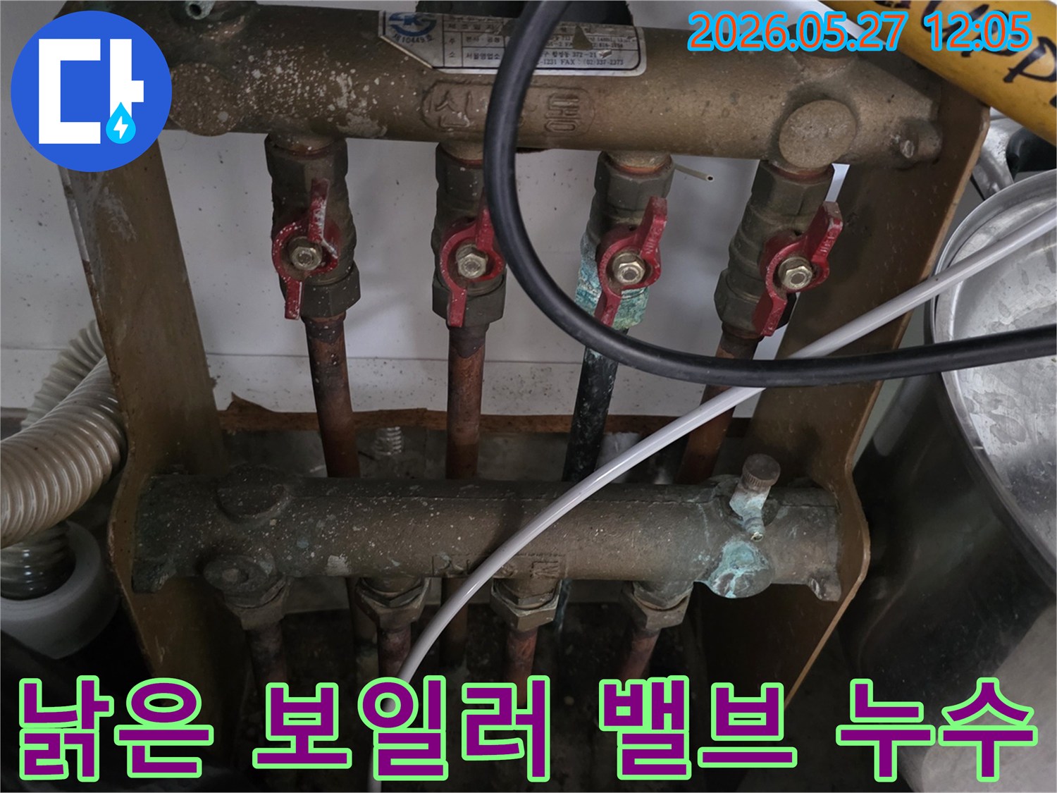 오래된 아파트의 보일러 분배기에 연결된-낡은 밸브에서-누수가 발생한 현장을-전문가가 점검하고 있습니다