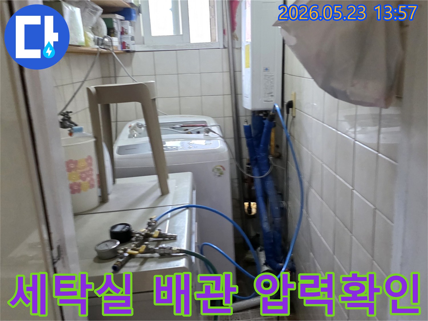 용마산로 빌라 세탁실에서 누수 원인을 찾기 위해 배관에 압력 검사 장비를 연결하여 확인하는 모습입니다-정확한 진단을 위한 첫 단계입니다