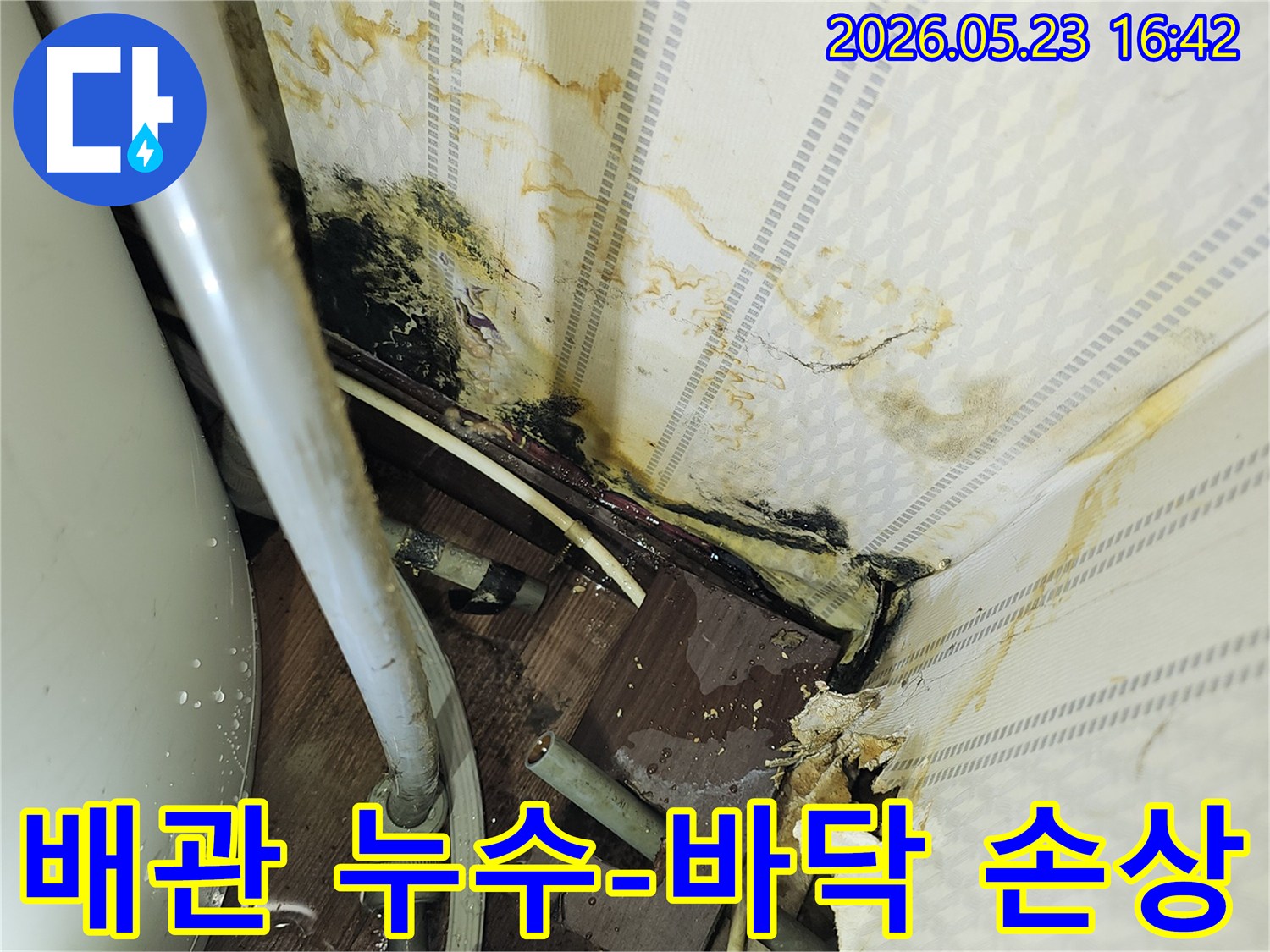노출된 배관 주변에서-물이 새어 나와-바닥과 벽면이 손상된-누수 현장 이미지입니다.