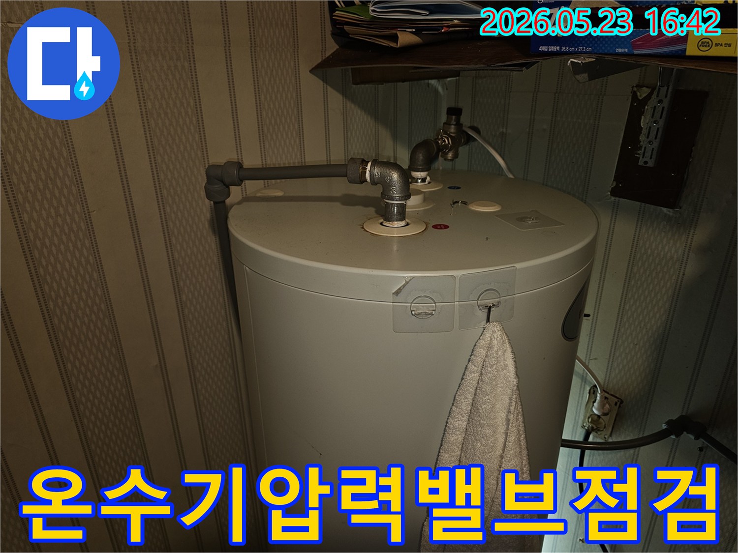 온수기-상단-배관과-압력-밸브에서-발생하는-누수-여부를-전문가가-점검하는-사진입니다