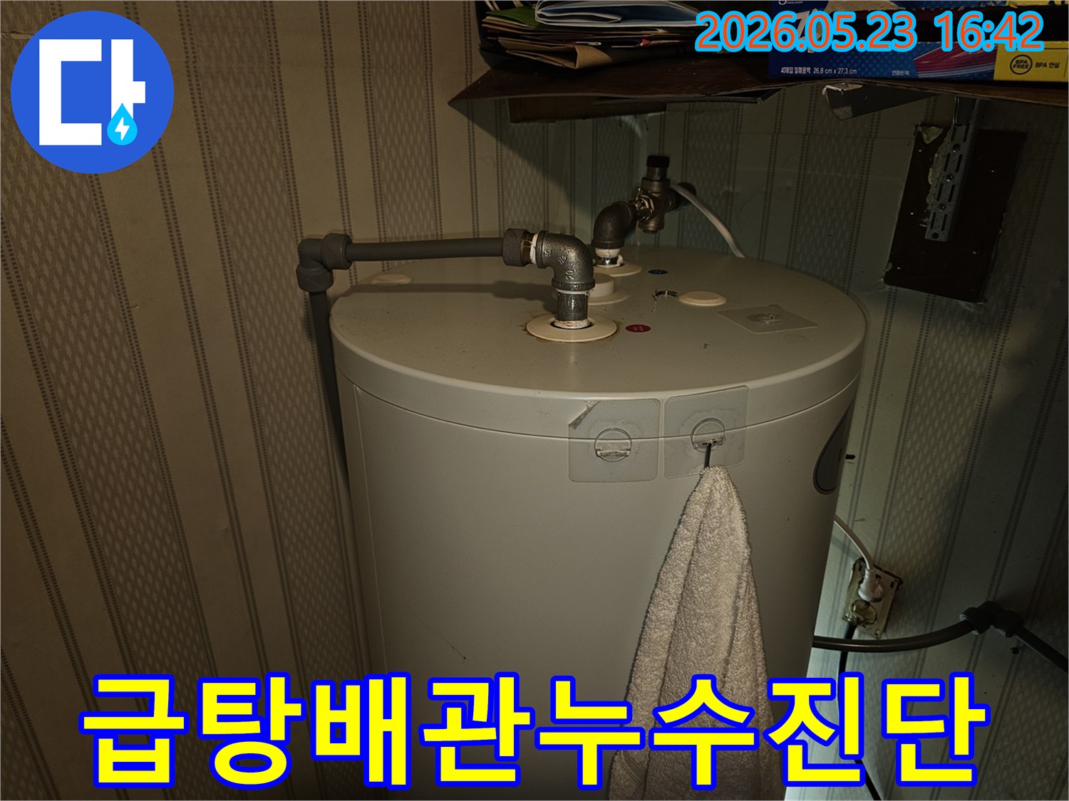 온수기-상단에-연결된-급탕-배관에서-발생할-수-있는-누수를-전문가가-점검하는-모습입니다
