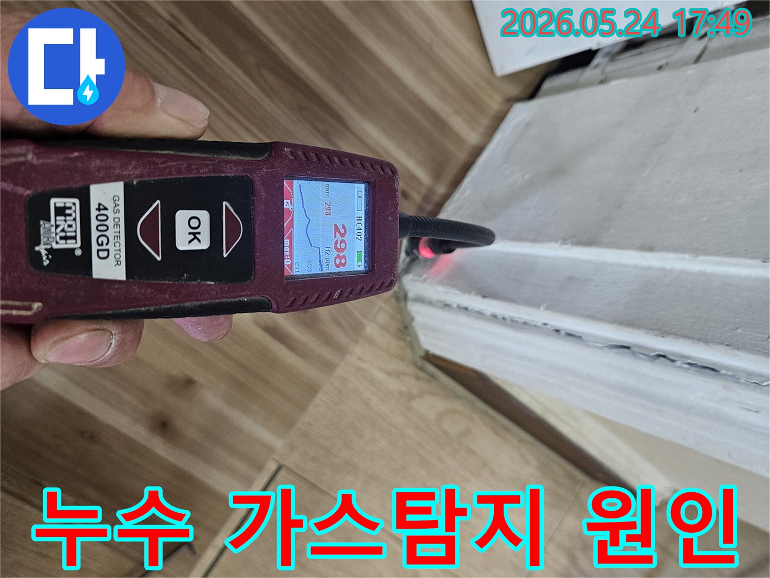 누수 엔지니어가 가스 탐지기를 사용하여 벽면과 바닥 경계에서 누수 반응을 정밀하게 확인하고 있습니다.