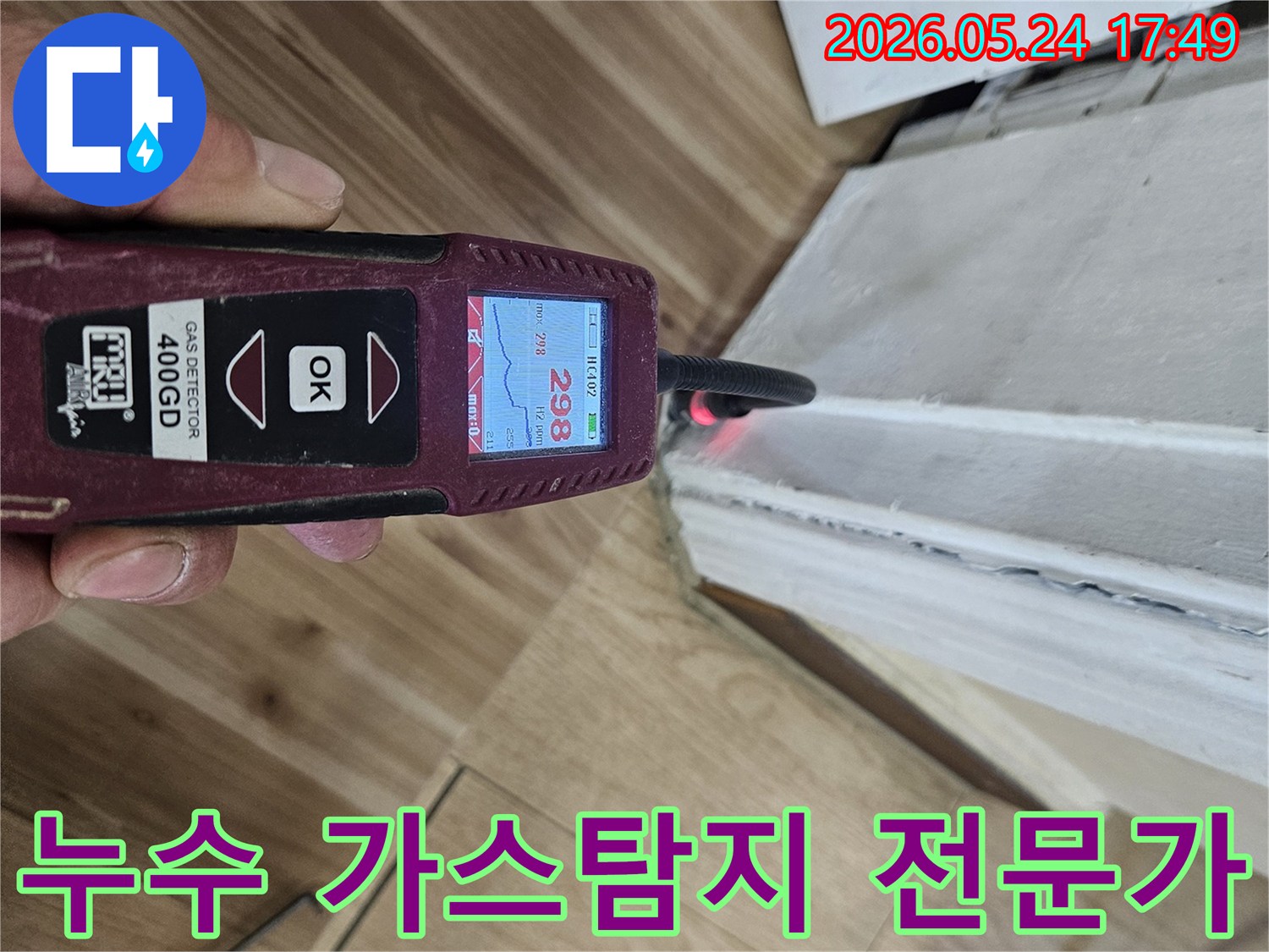 누수 엔지니어가 가스 탐지기를 사용하여 벽면과 바닥 경계에서 누수 반응을 정밀하게 확인하고 있습니다.