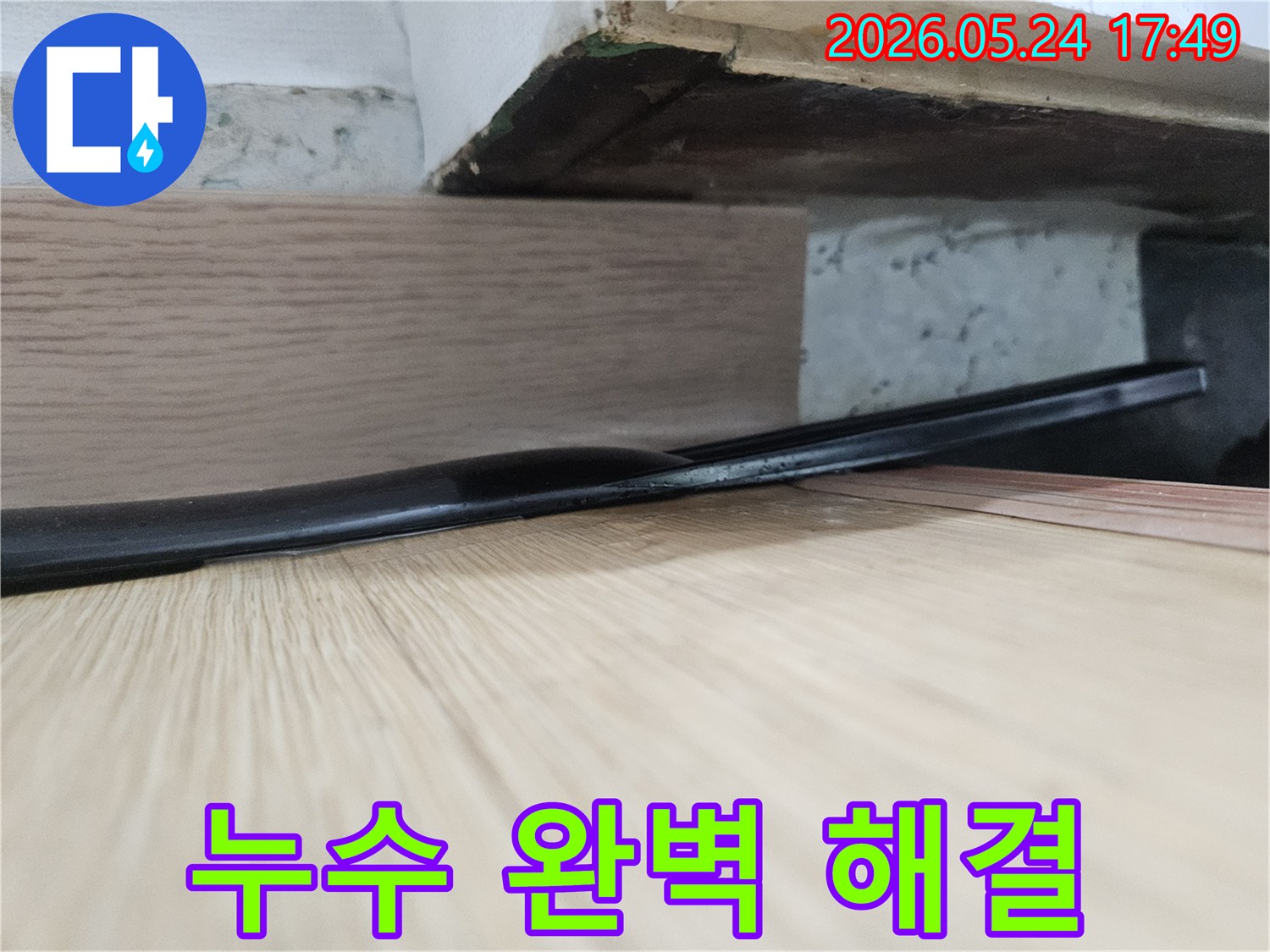 누수로 인해-습기와-변색이 발생한-마루 아래-자재는-완벽한-누수 해결과-복구 시공이-필요함을-보여줍니다