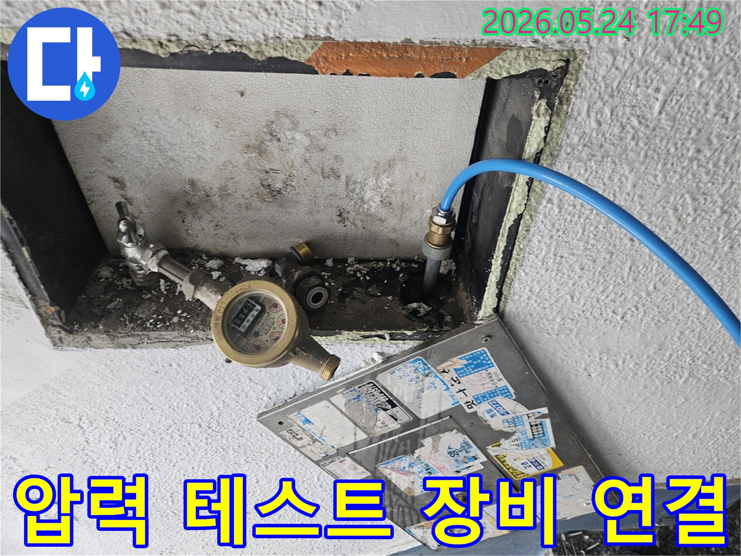 아파트 누수 진단을 위해 압력 테스트 장비를 수도관에 연결하는 모습-정확한 누수 지점 파악에 필수적입니다