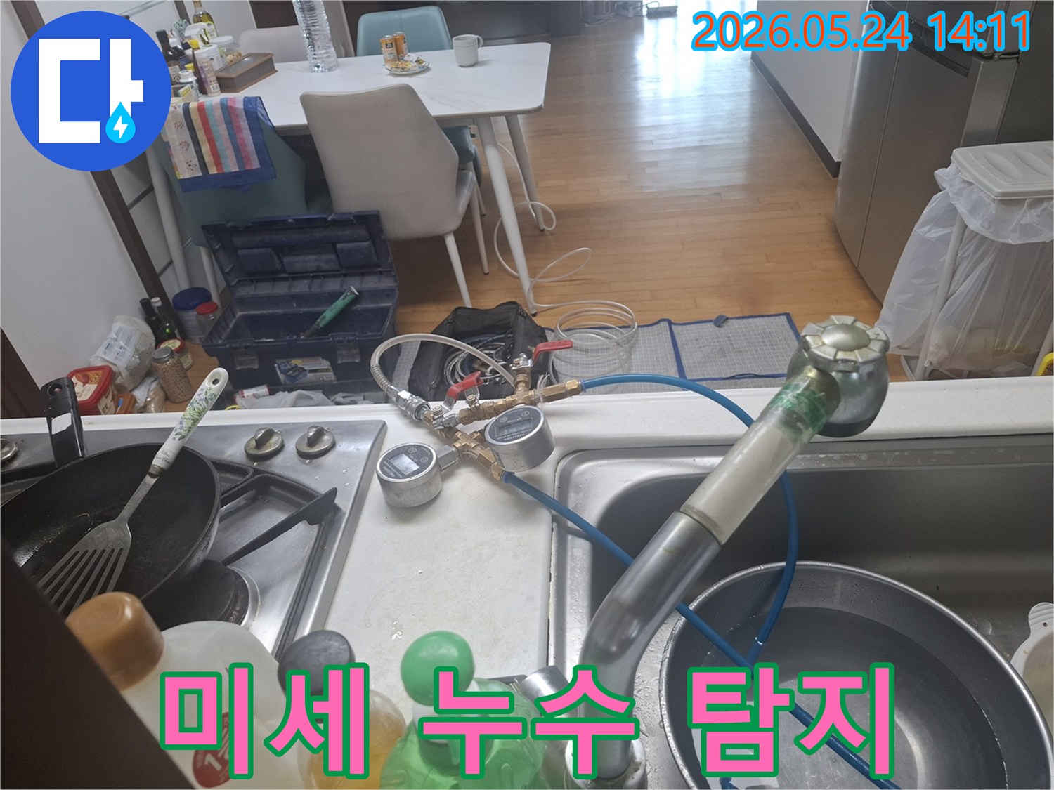 정확한 누수 지점을 파악하기 위해-싱크대 수도에-압력 측정 장치를-설치하고-점검하는-모습입니다
