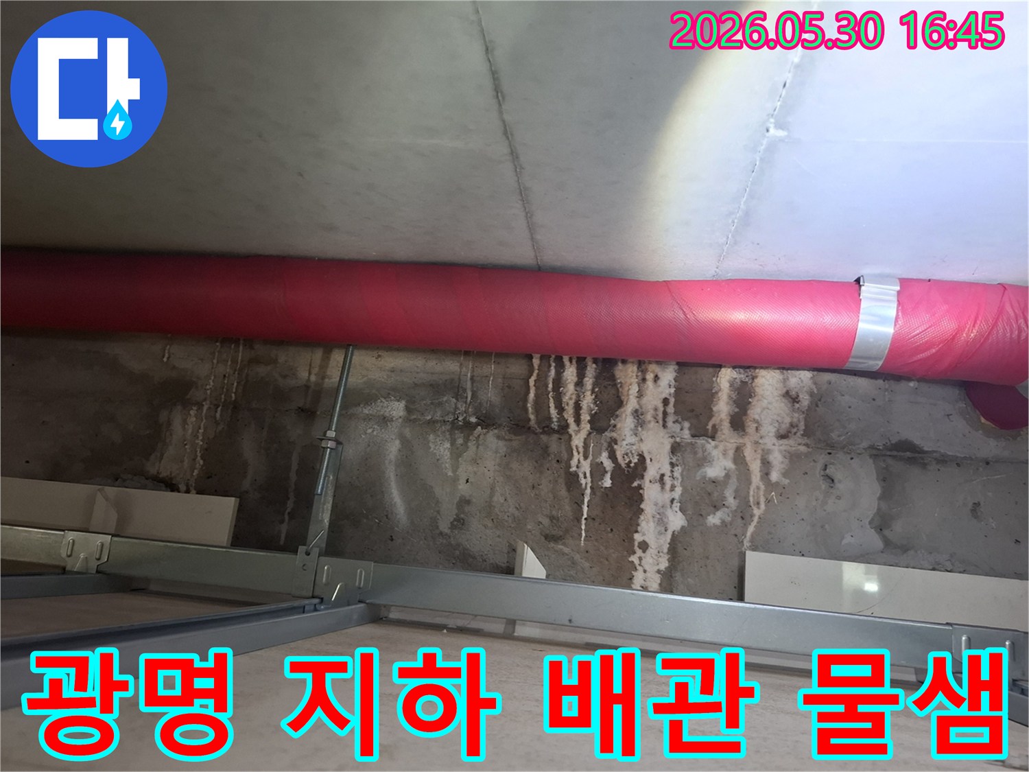 광명시 아파트 지하에서- 붉은 배관 하단으로- 물이 새어 나온 흔적을- 엔지니어가 파악하는 모습