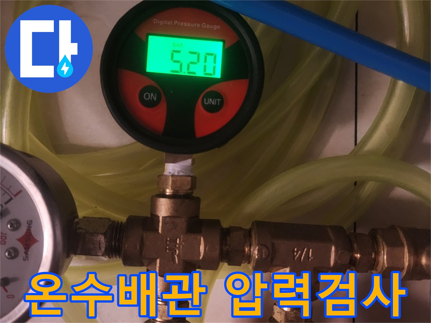 이 이미지는 주거 시설의 온수 배관에서-누수 여부를 정밀하게 확인하기 위해-디지털 압력 게이지를 사용하여-배관의 압력 상태를 면밀히 검사하는 과정을 보여줍니다.