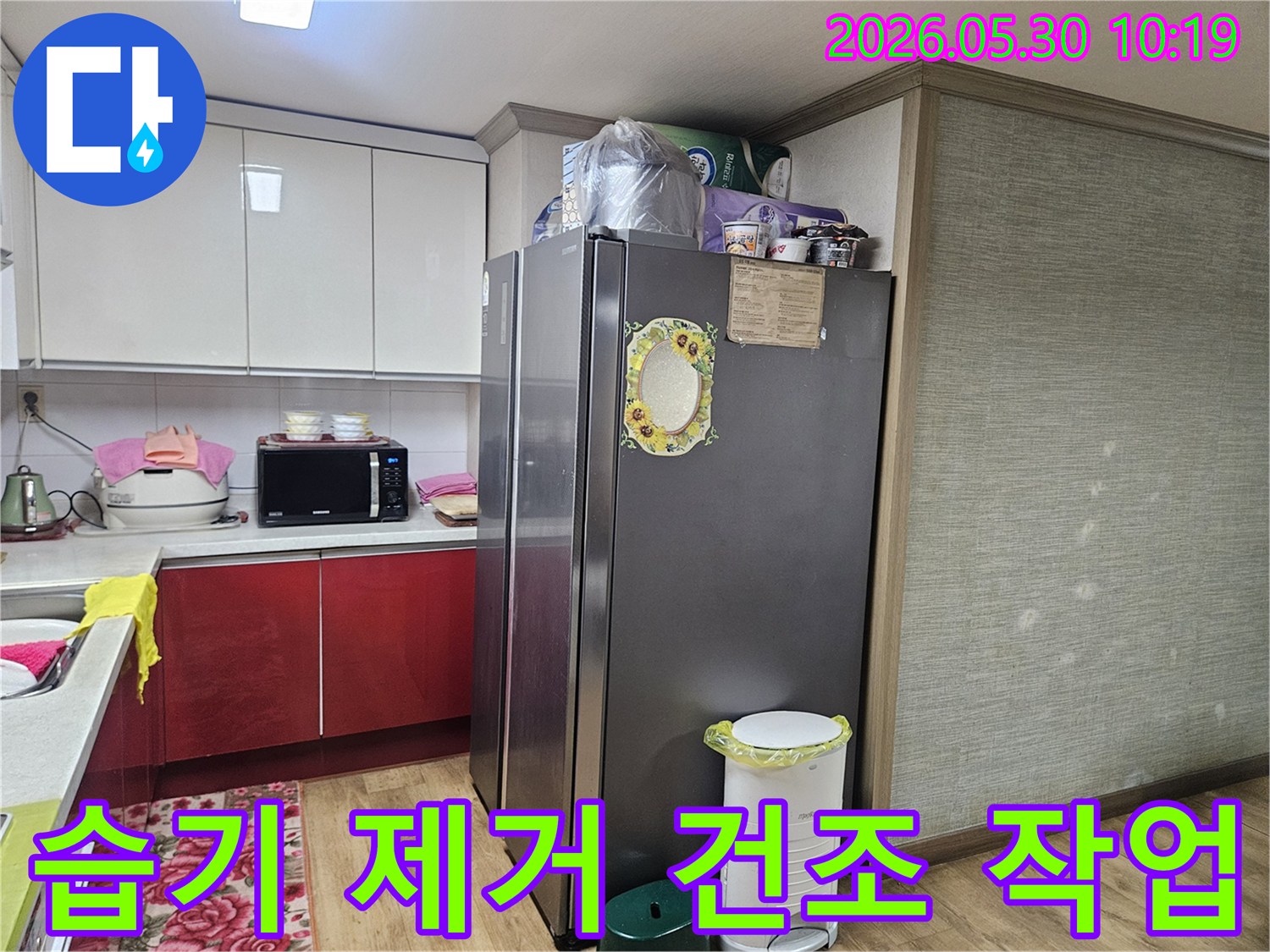 누수 엔지니어가-강동구 천호동 아파트 주방에서-가전제품 주변의 습기를 제거하고-건조 작업을 준비하고 있습니다