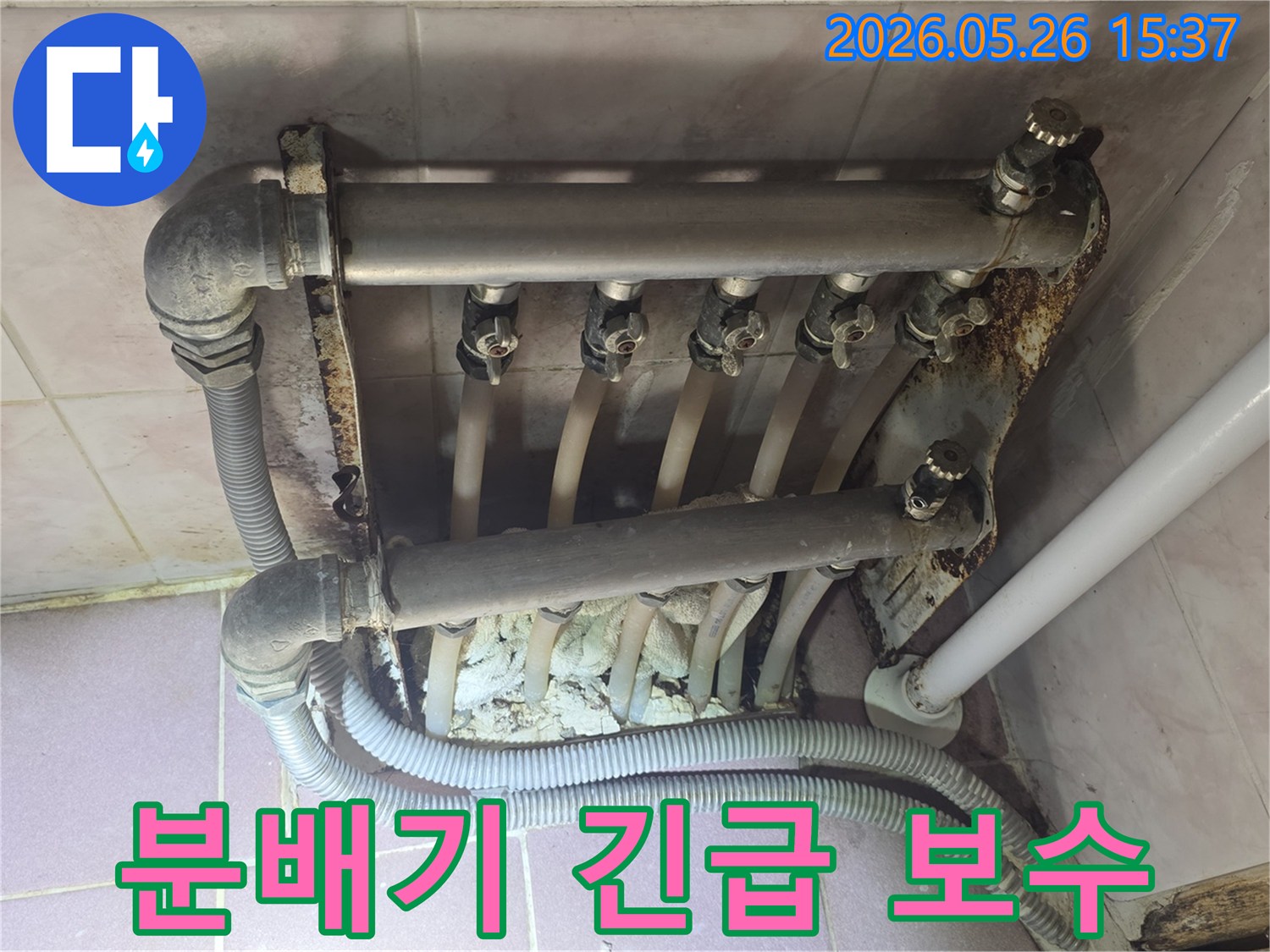 난방 분배기에서 발생한 누수 흔적과 심각한 부식 상태를 보여주며-긴급 보수가 필요한 현장 이미지