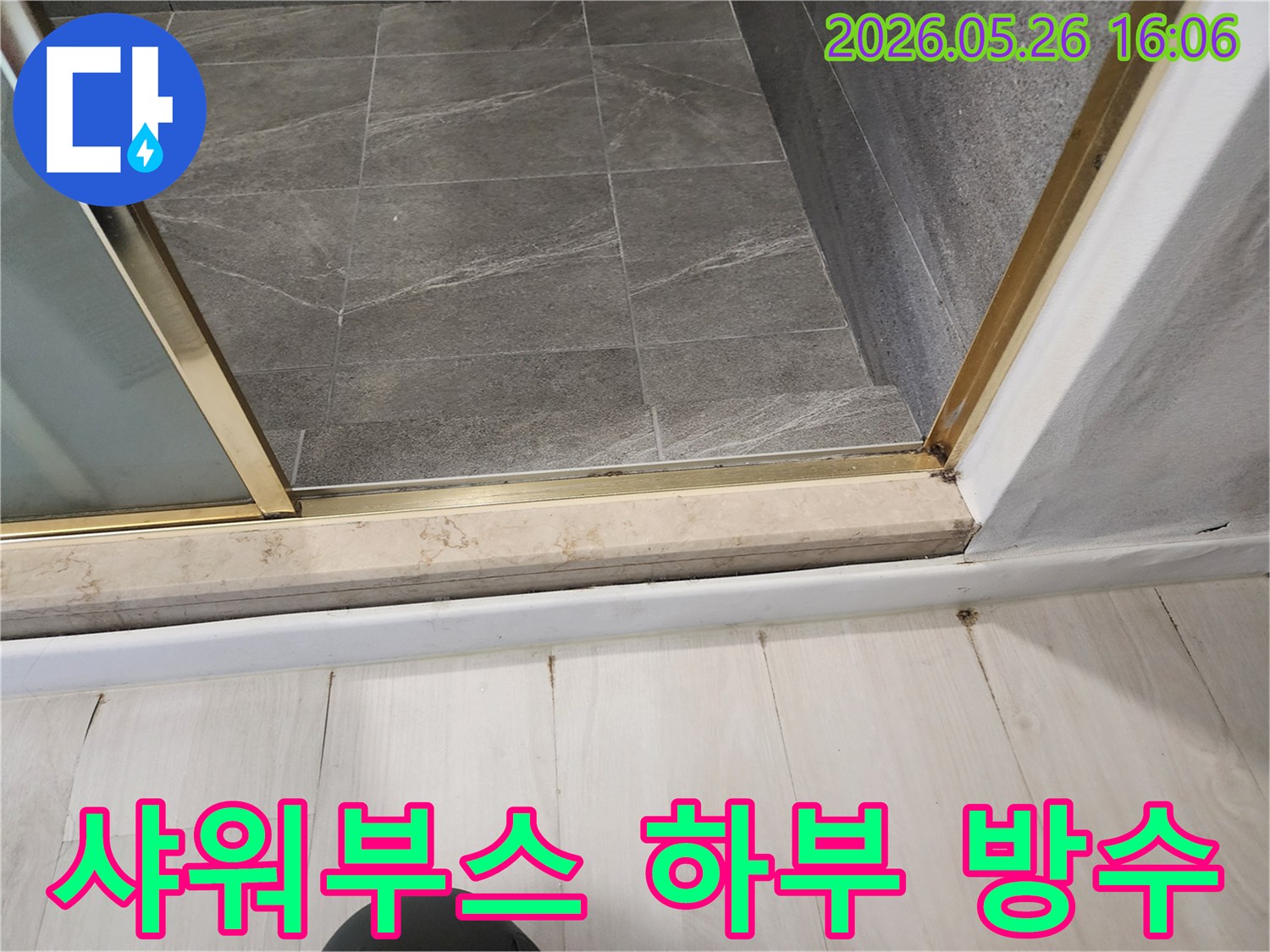 욕실-샤워부스-하부에서-물이-새어-나와-바닥에-손상을-주고-있는-누수-현장-사진