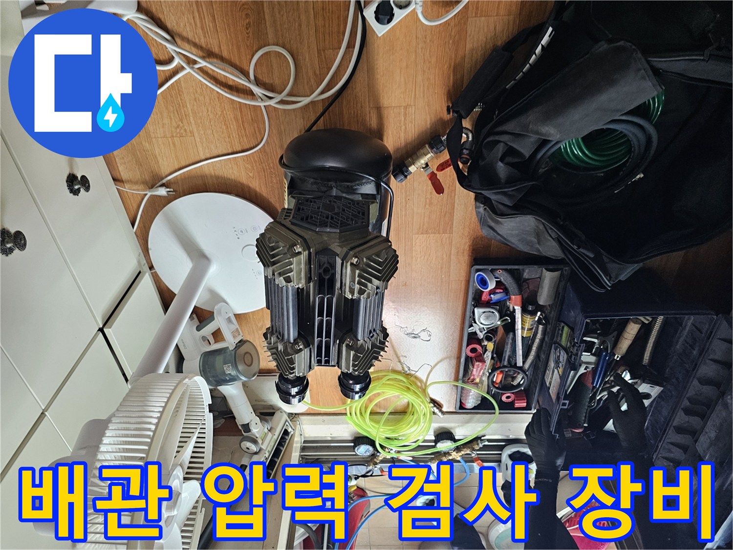 싱크대 하부 누수 점검을 위해 설치된 공압 테스트용 컴프레셔와 각종 공구들