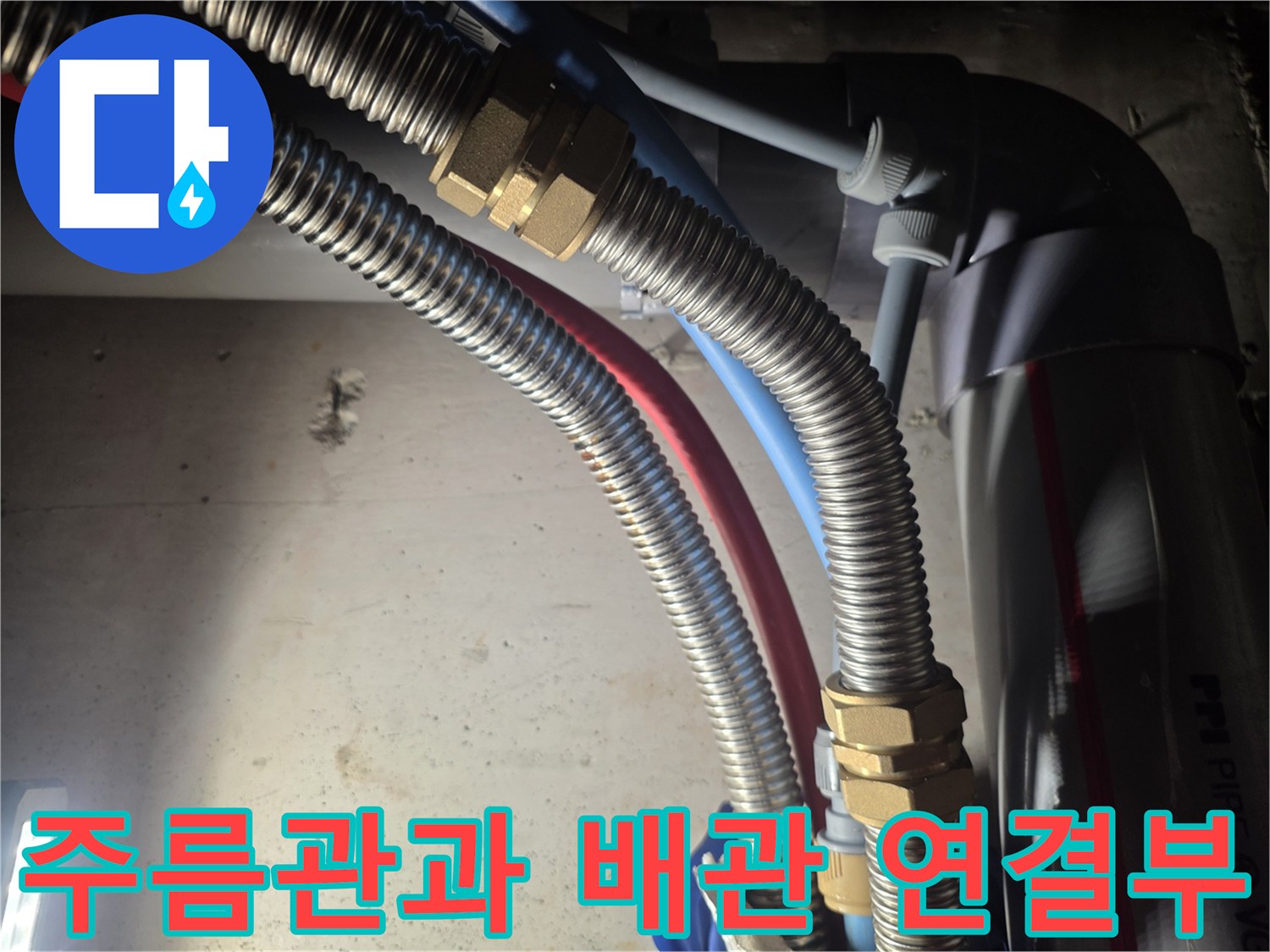 금속 재질 주름관과 파란색 호스의 복합적인 연결 구조
