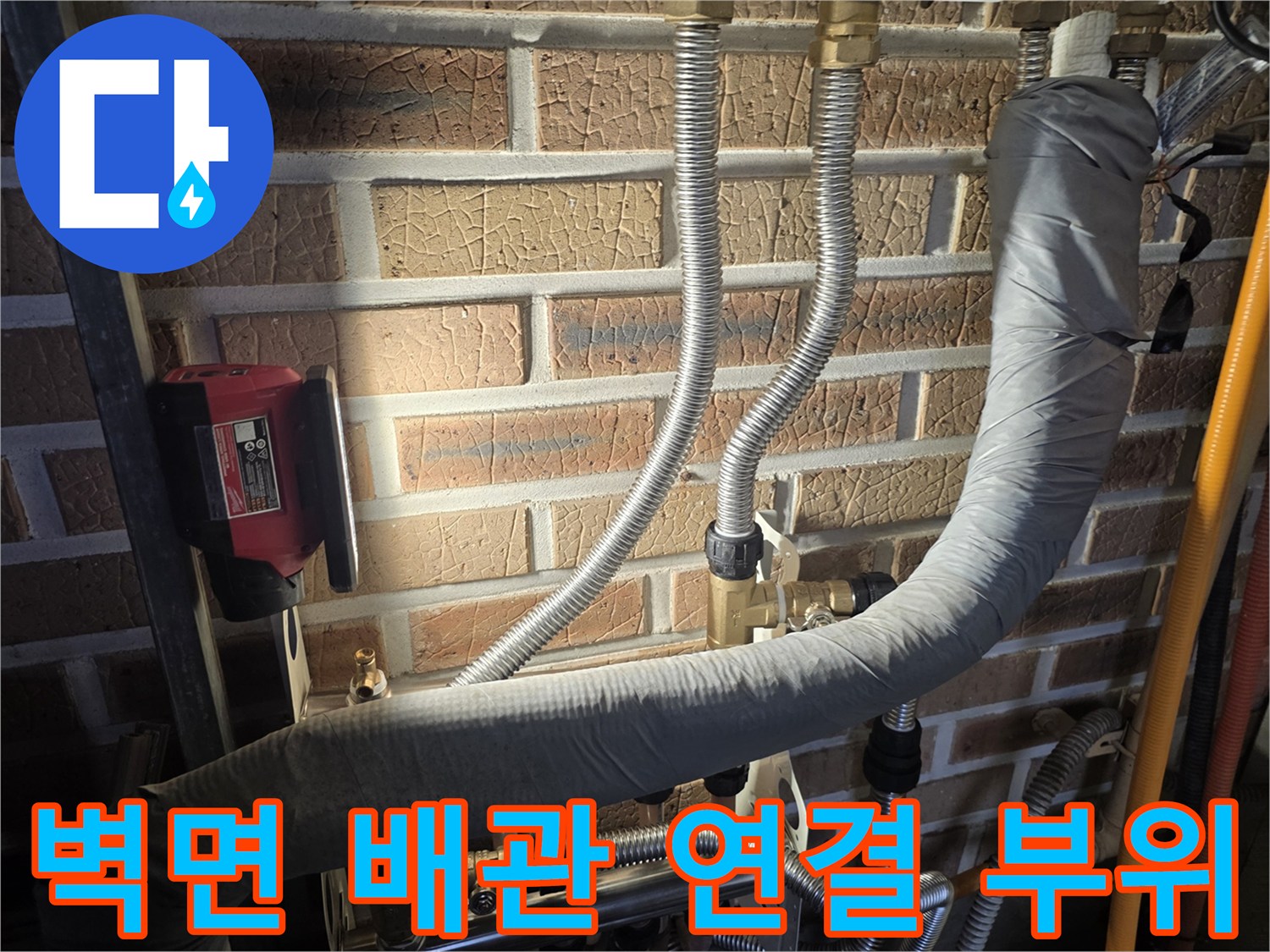 벽돌 벽면에 설치된 수도 배관과 압력 측정 장비의 모습