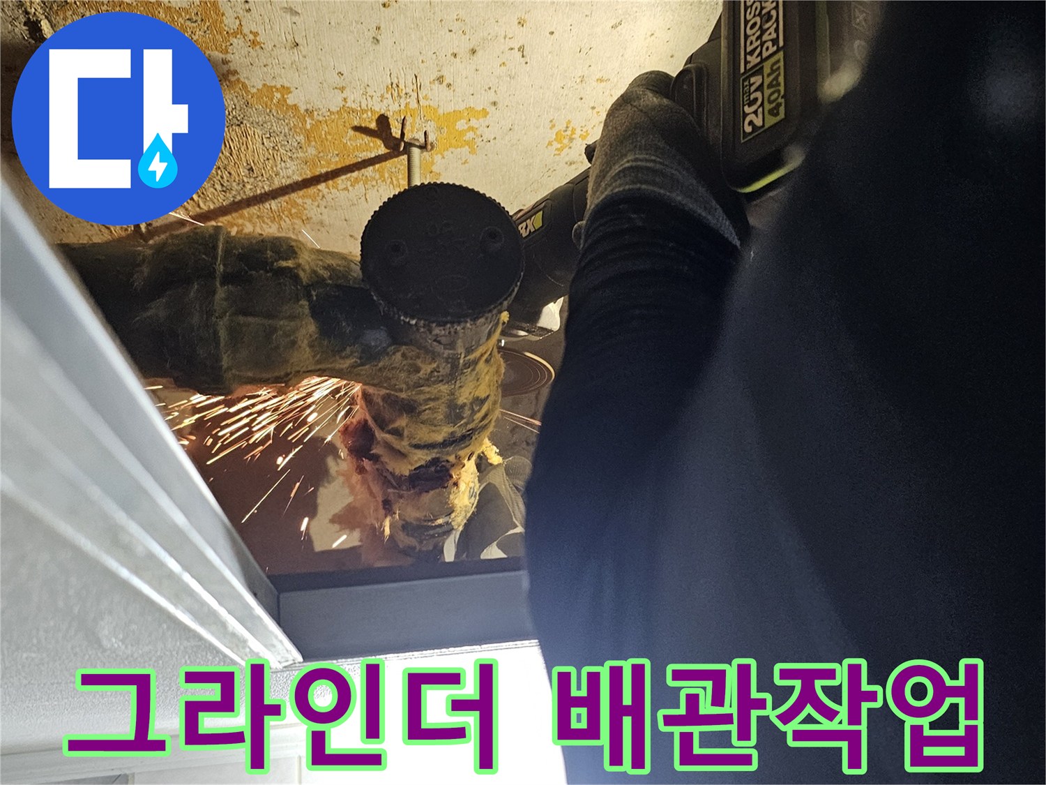 배관의 파손된 부위를 제거하기 위해 전동 공구를 사용하는 장면입니다.