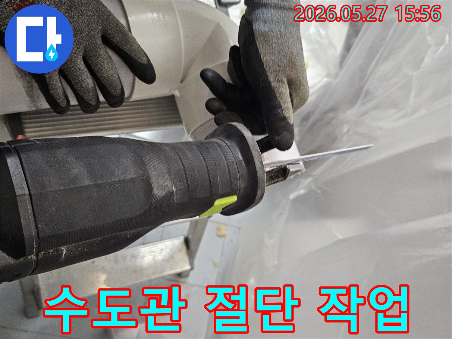 전문-작업자가-안전장갑을-착용하고-전기톱으로-수도관-PVC-파이프를-정밀하게-절단하고-있습니다