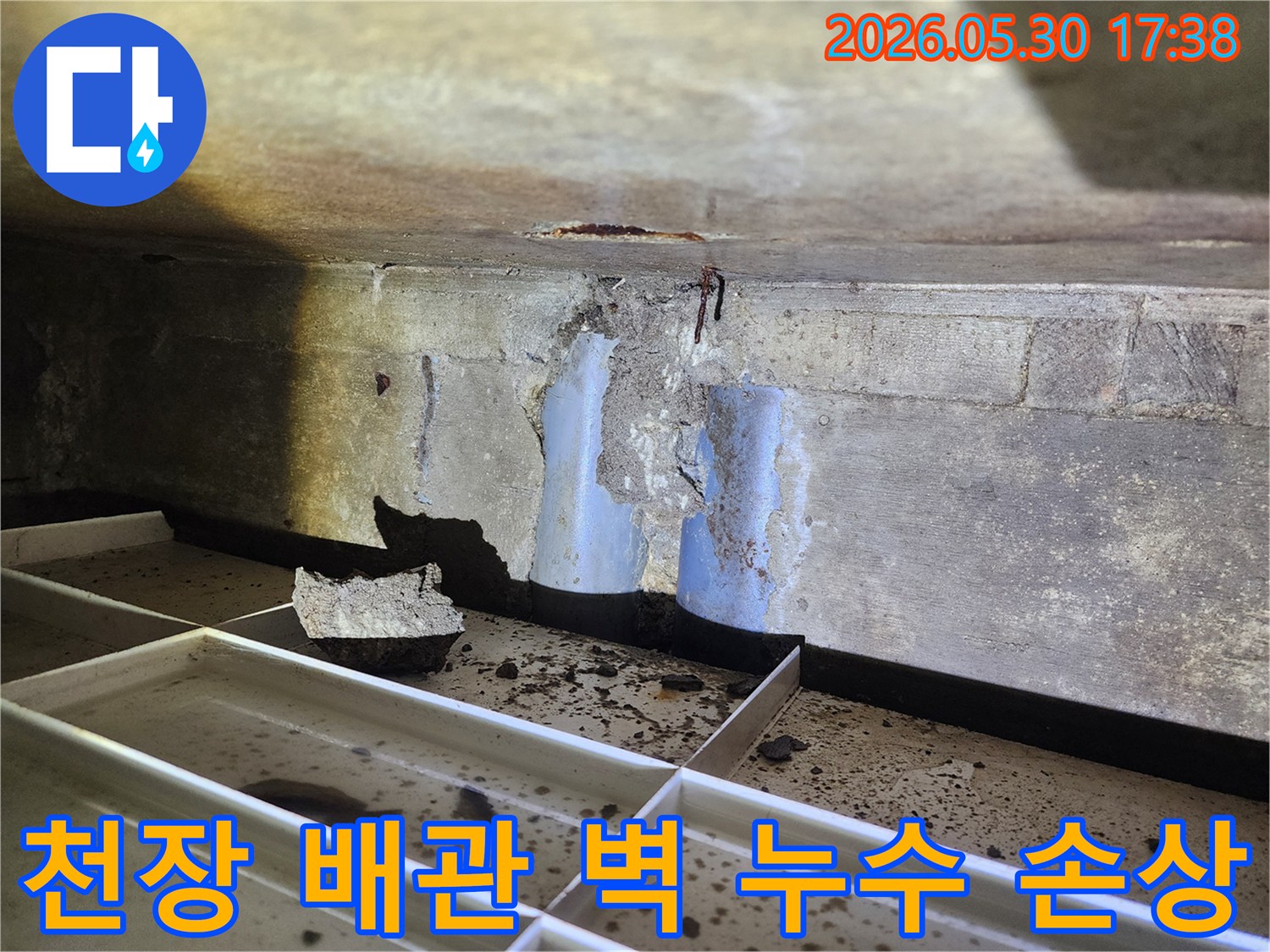 천장-배관-누수로-인해-벽면-콘크리트가-손상되고-배관이-노출된-현장-모습