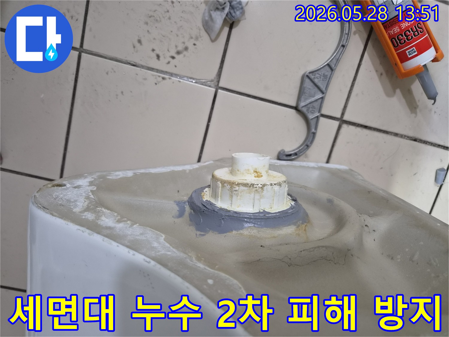 세면대 배수구 누수로 인한 2차 피해를 막기 위해-전문가가 배수관 연결 부위를 보수하는 모습입니다.