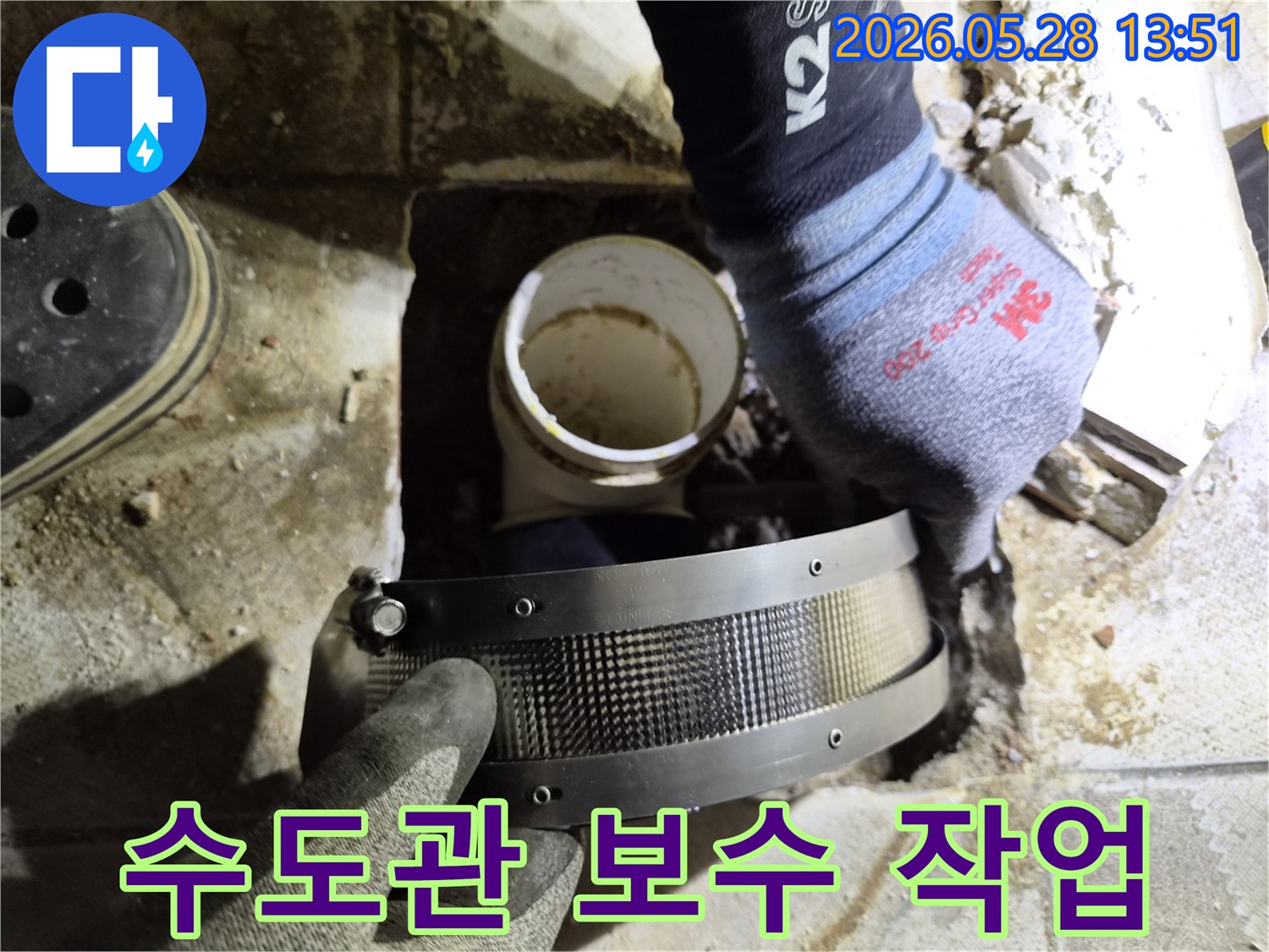 작업자가 보호 장갑을 착용하고-수도관의 누수 발생 부위에-보수 밴드를 설치하는 중입니다