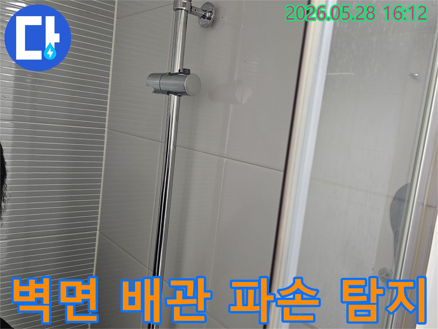 이 이미지는-주택 화장실 샤워부스 벽면의-타일과 샤워바 설치 부위를-점검하여-벽면 내부의 배관 파손 여부를-탐지하는 과정입니다.