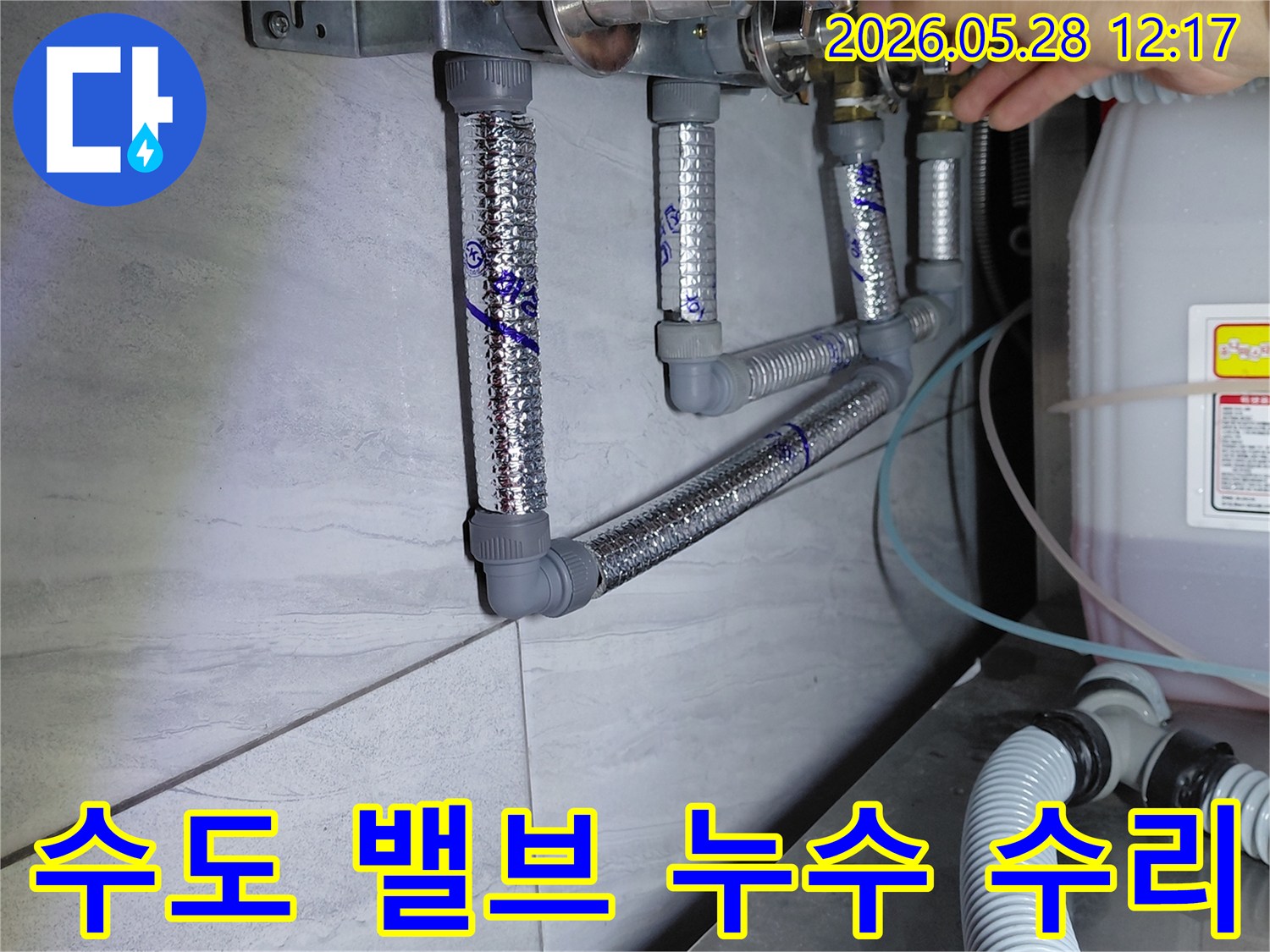 수도 배관의 밸브에서 발생한 누수를-전문가가 직접 확인하고 수리 준비를 하는 모습