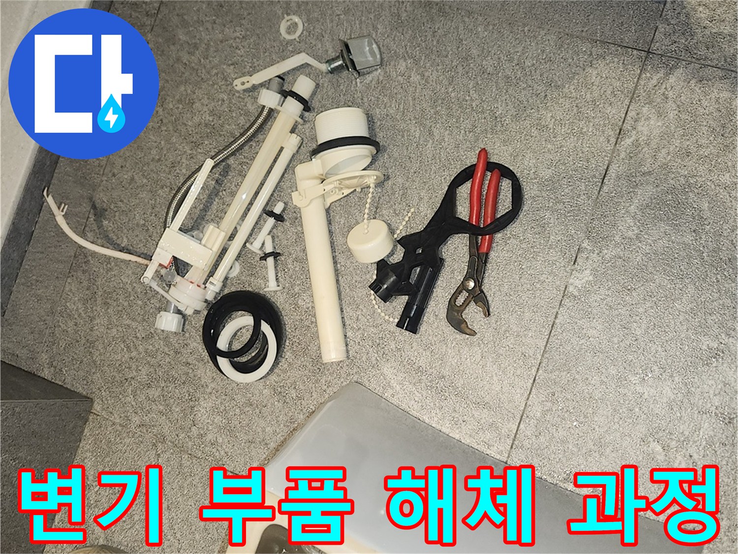 변기 수리를 위해 바닥에 분리된-오래된 변기 부속들과 작업 도구들이 놓여 있습니다.
