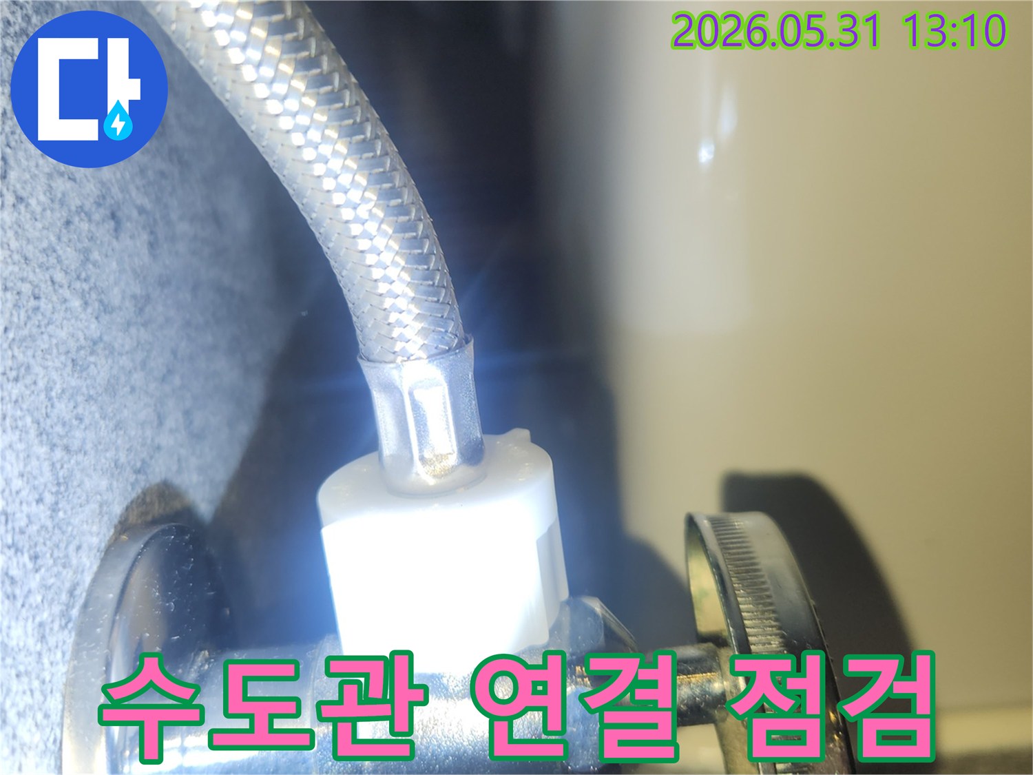 수도 밸브와 연결된 호스에서-누수가 없는지-정밀하게 확인하는 순간을 담았습니다.