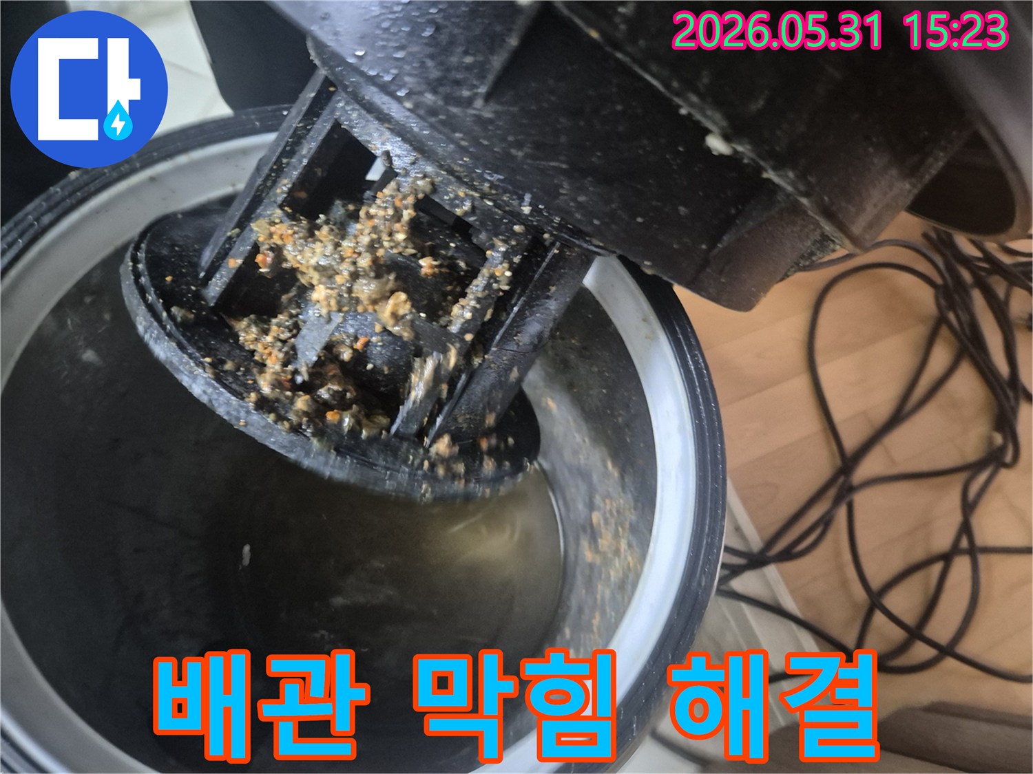파주 청석마을 아파트에서-누수 엔지니어가-배관 막힘의 원인인-이물질을 석션 장비로 제거하여-문제를 해결하는 모습
