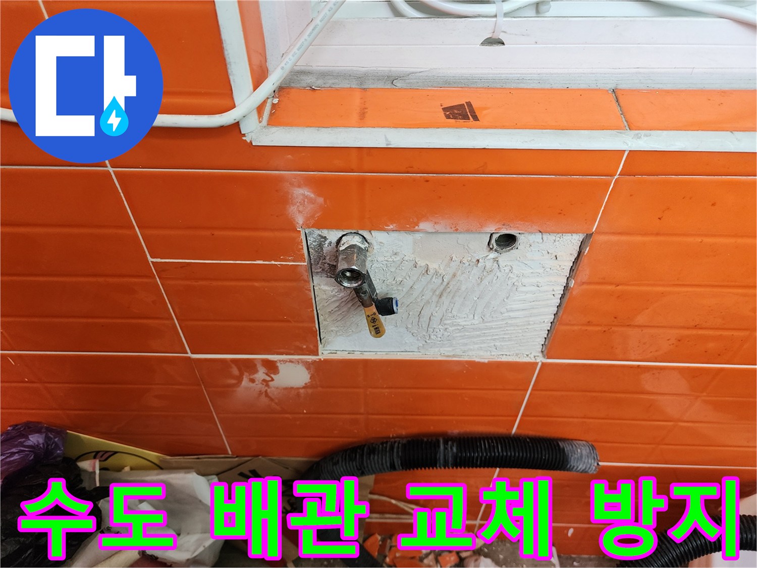 오렌지색 타일 벽면의-노후된 수도 배관을-새로운 것으로 교체하고-누수를 방지하는 작업 현장