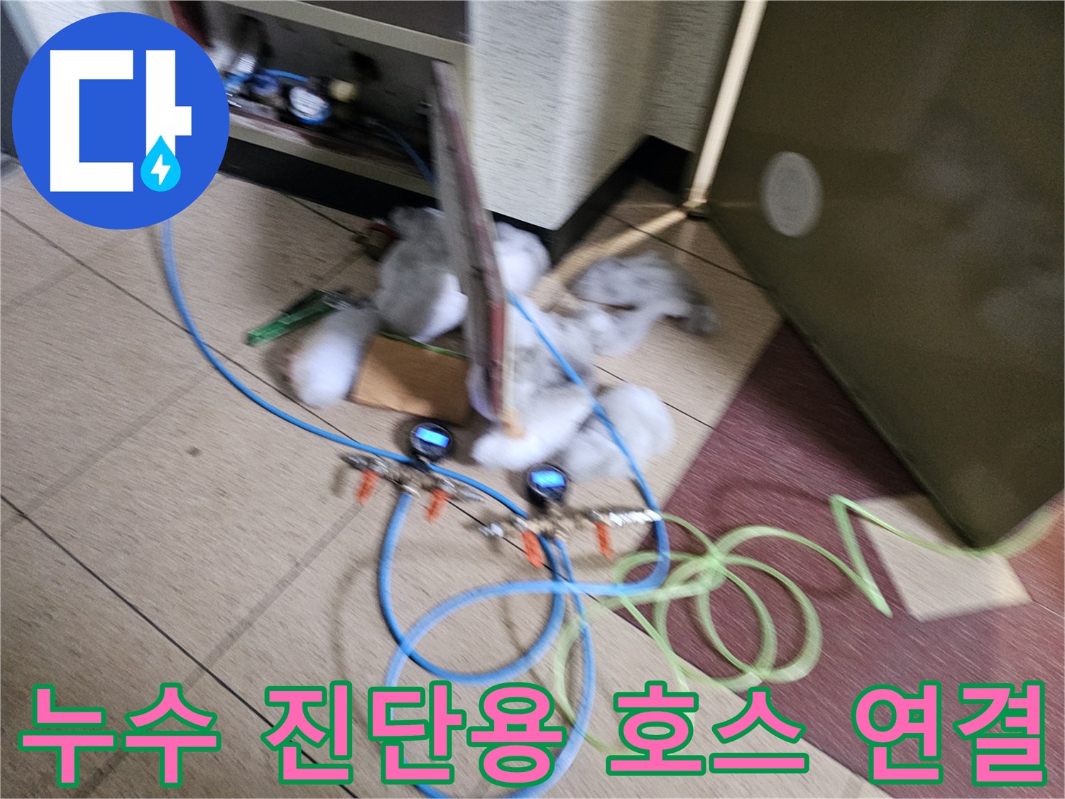 화장실 바닥 작업-배관 점검을 위해 연결된 파란색 에어 호스와 게이지