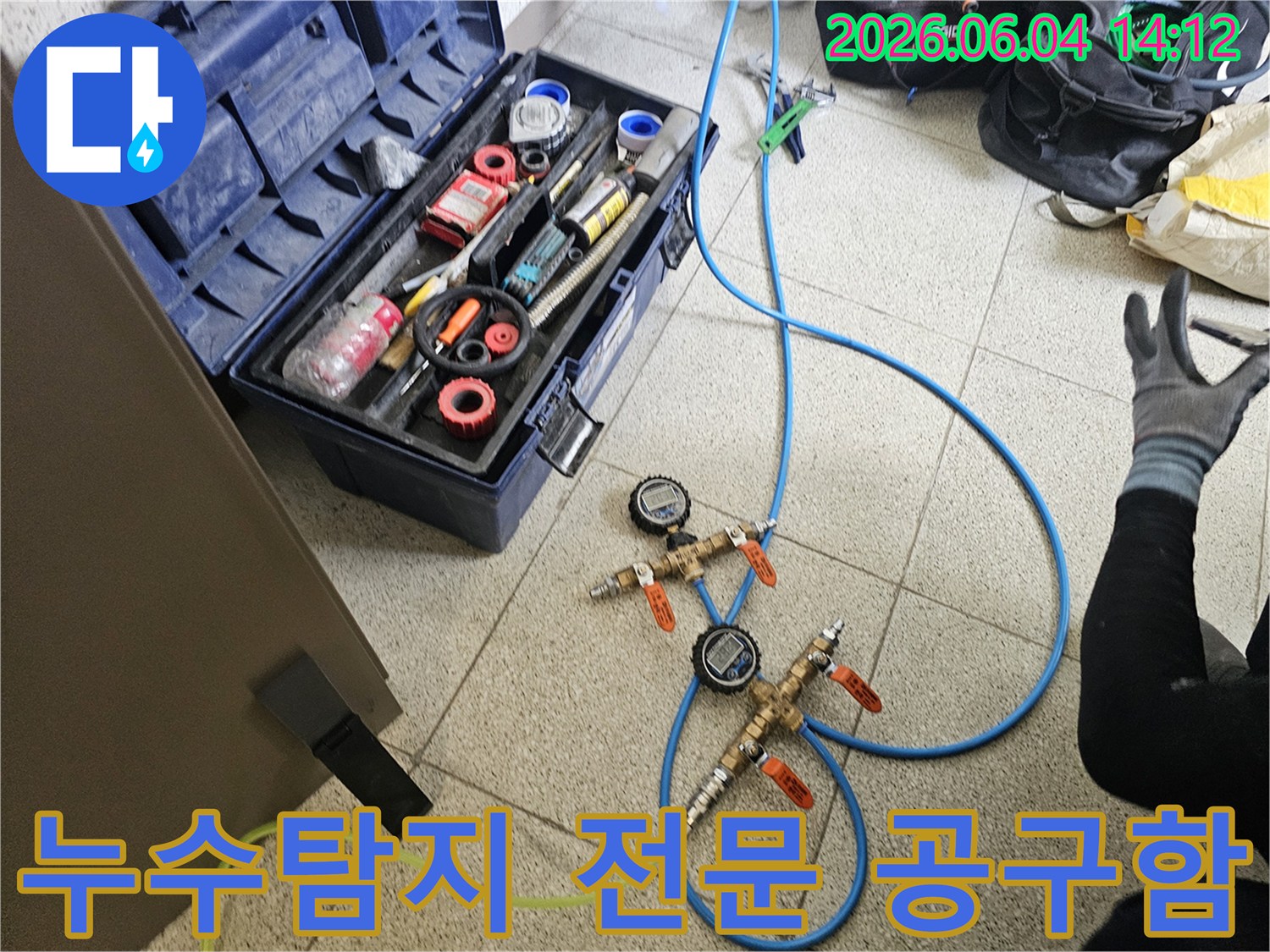 누수-탐지 작업을-위해-다양한-전문-공구들이-정돈되어-있는-공구함과-압력-측정-장비가-보이는-현장입니다.
