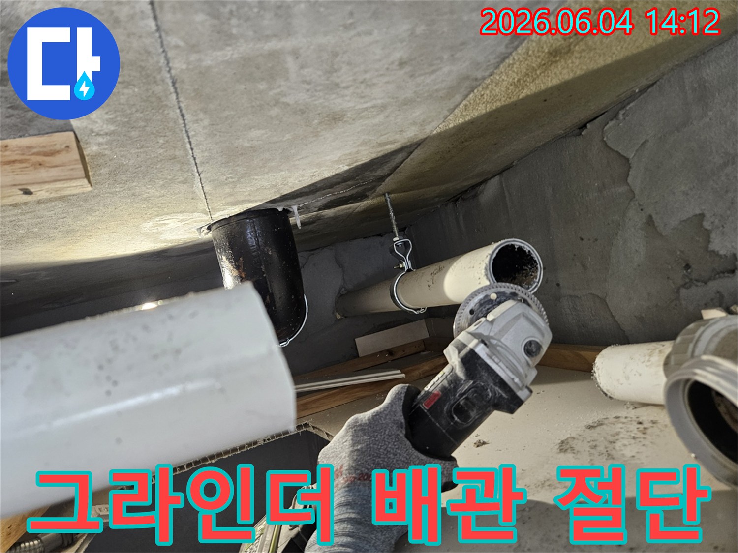 누수된 배관을 교체하기 위해 그라인더를 사용하여 절단하는 전문 기술자의 모습