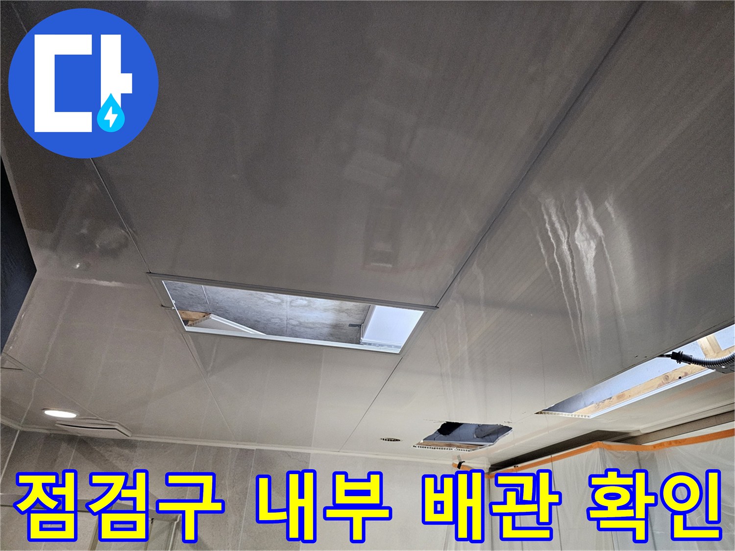 천장 점검구를 통해 내부 배관의 누수 여부를 검사하는 중입니다.