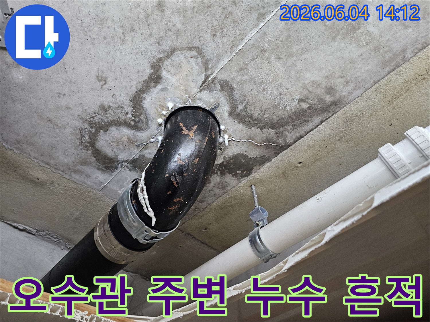 천장 콘크리트에서 오수관 주변으로 물이 새는 흔적을 보여주는-누수 현장 사진