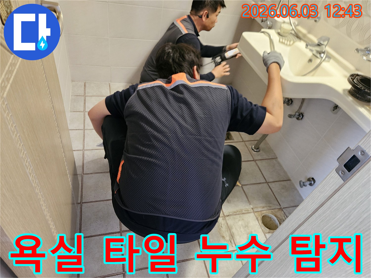 서울 중랑구 빌라 욕실에서-두 명의 전문 기술자가-타일 사이의 누수 여부를-정밀하게 탐지하는 모습