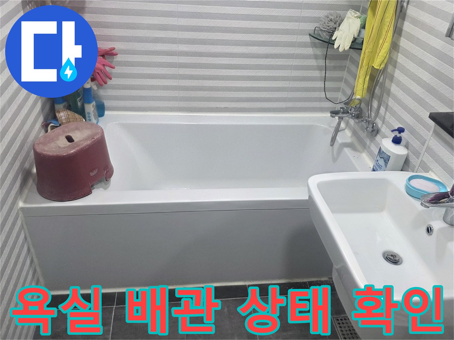 세면대 하부와 욕조 벽면 타일의 연결 부위를 면밀히 조사하는 장면