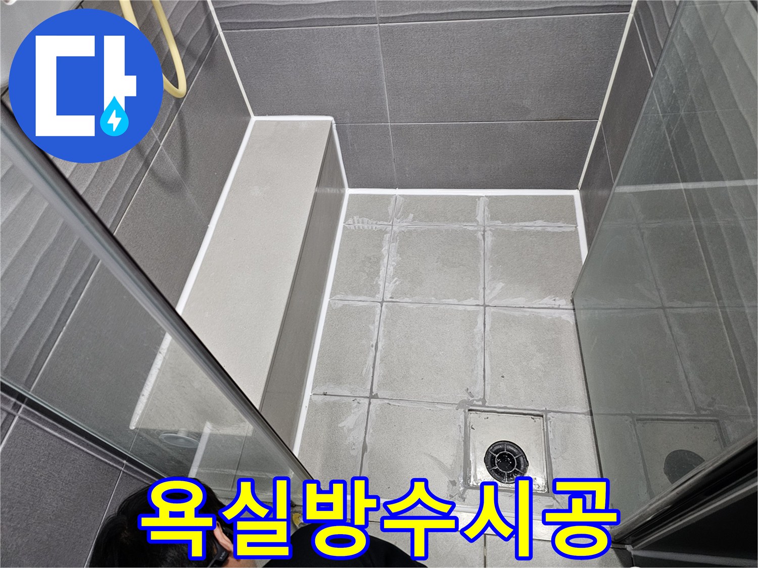 욕실-샤워실 바닥 타일 틈새에 발생한 누수를-전문가가 정밀하게 진단하고 보수하는 모습입니다.