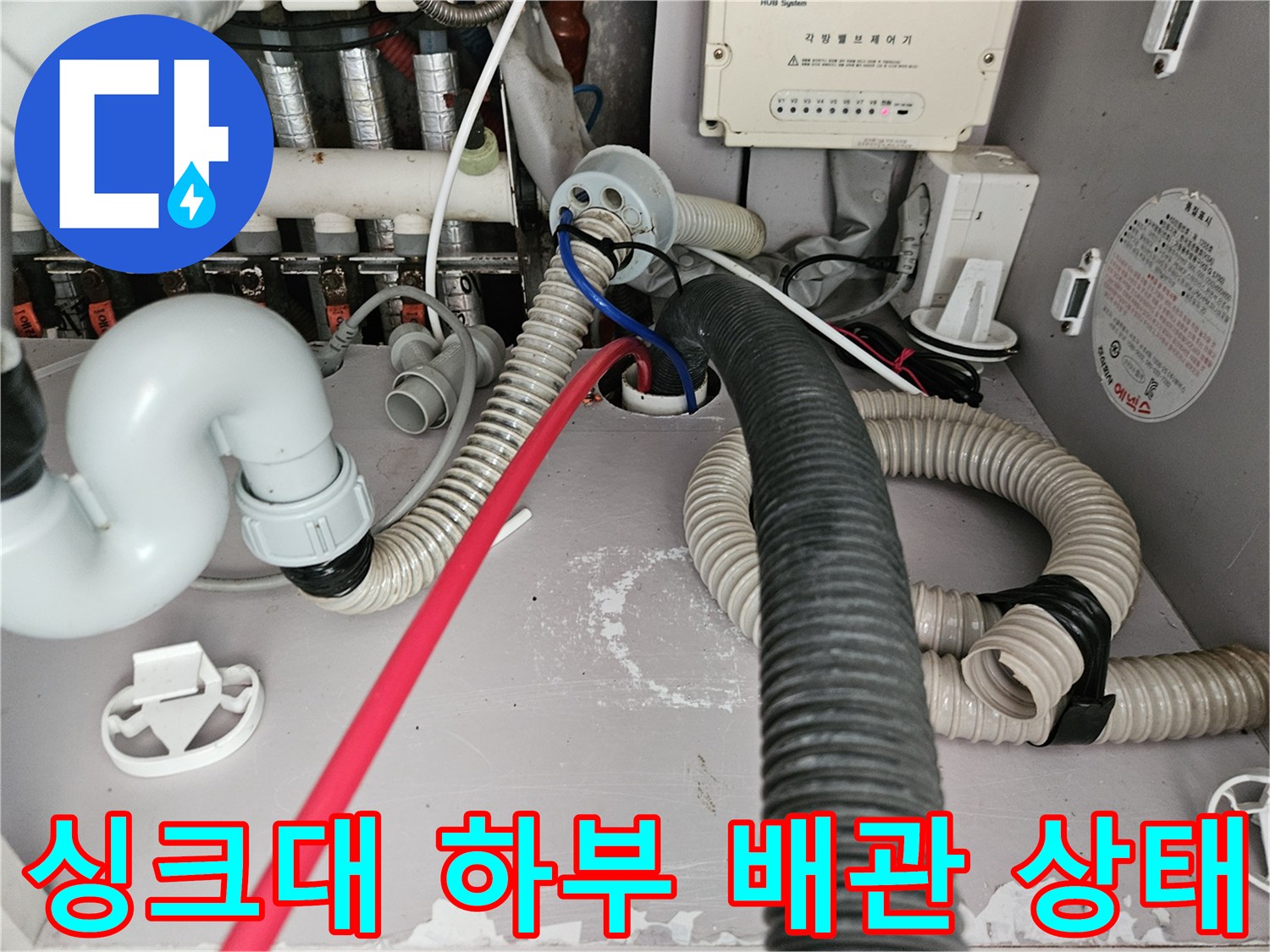 김포 장기동 싱크대 하부장 내부의 복잡한 배수 호스와 급수 밸브 모습