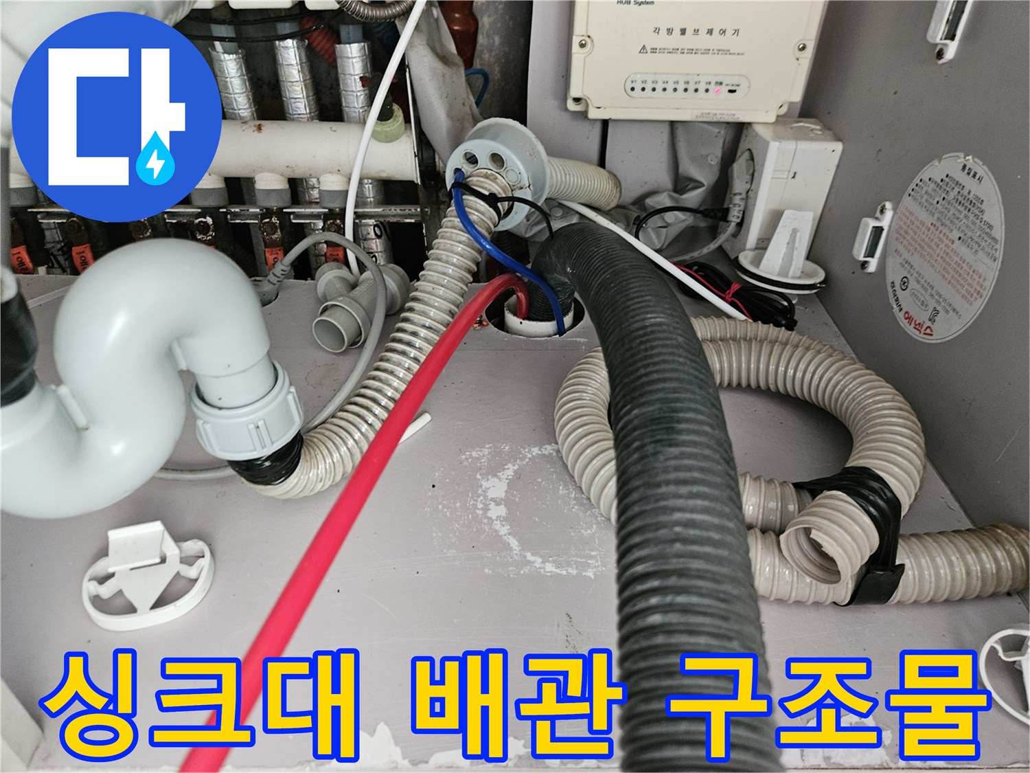 하부장에-연결된-흰색-배수관과-검은색-주름관의-모습