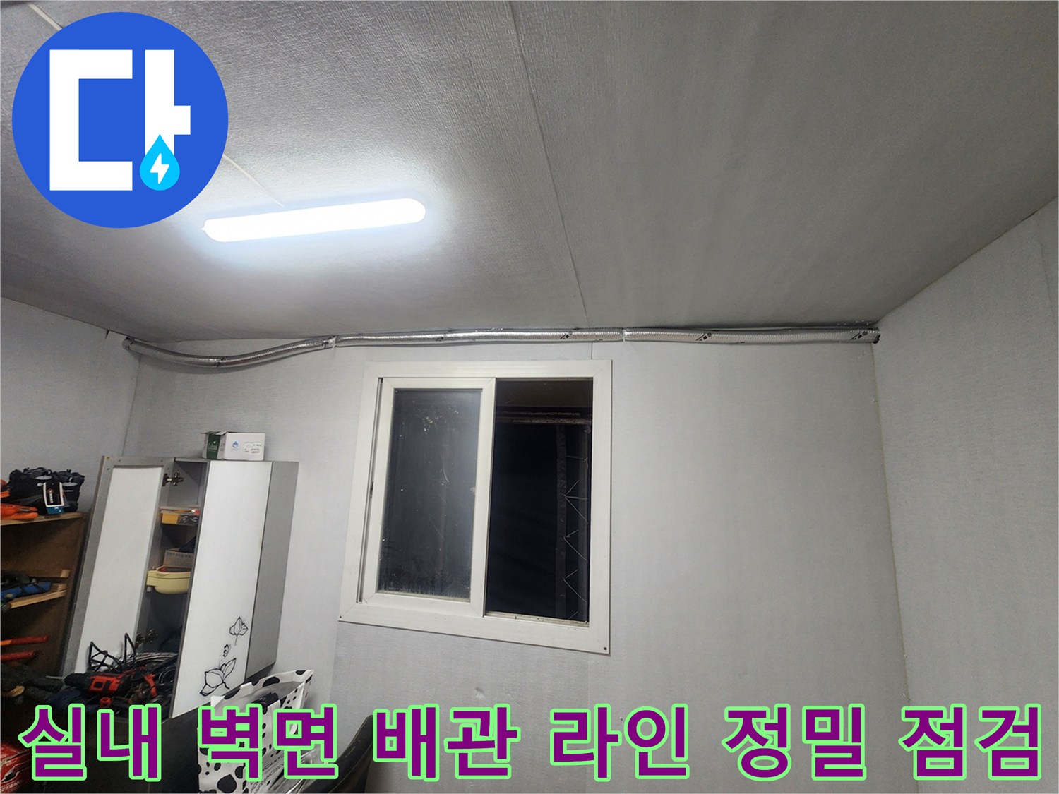 벽면과 천장이 만나는 지점의 배관 상태를 면밀하게 조사하는 현장 사진