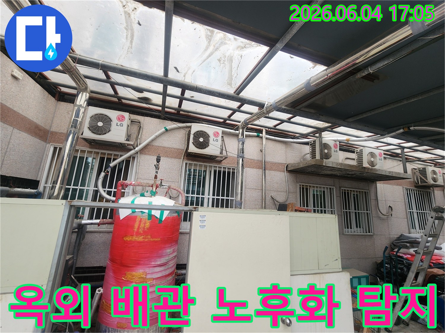 이 이미지는 주택 외부에 설치된-오래된 배관들과-다양한 설비들이 복합적으로 배치된 모습을 보여줍니다