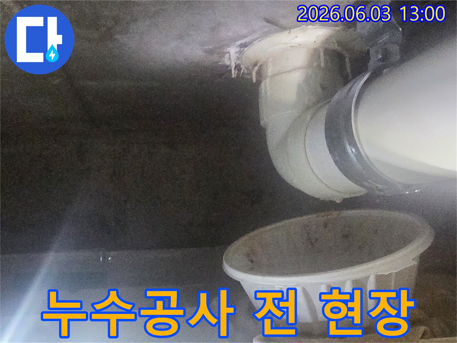 누수-공사-전에-물이-새는-배관과-임시-물받이가-놓인-현장-모습