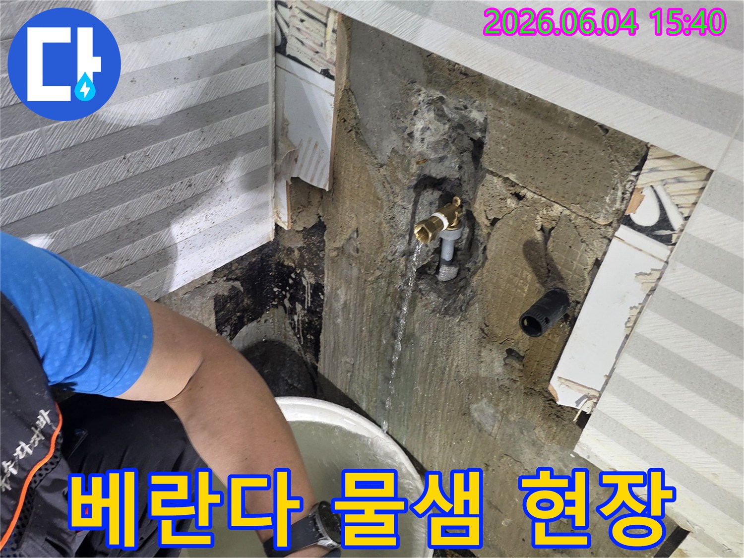 베란다 수도꼭지에서-물이 새는-현장에서-누수 전문가가-물을 받아내며-상황을-정밀하게-분석하고 있습니다.